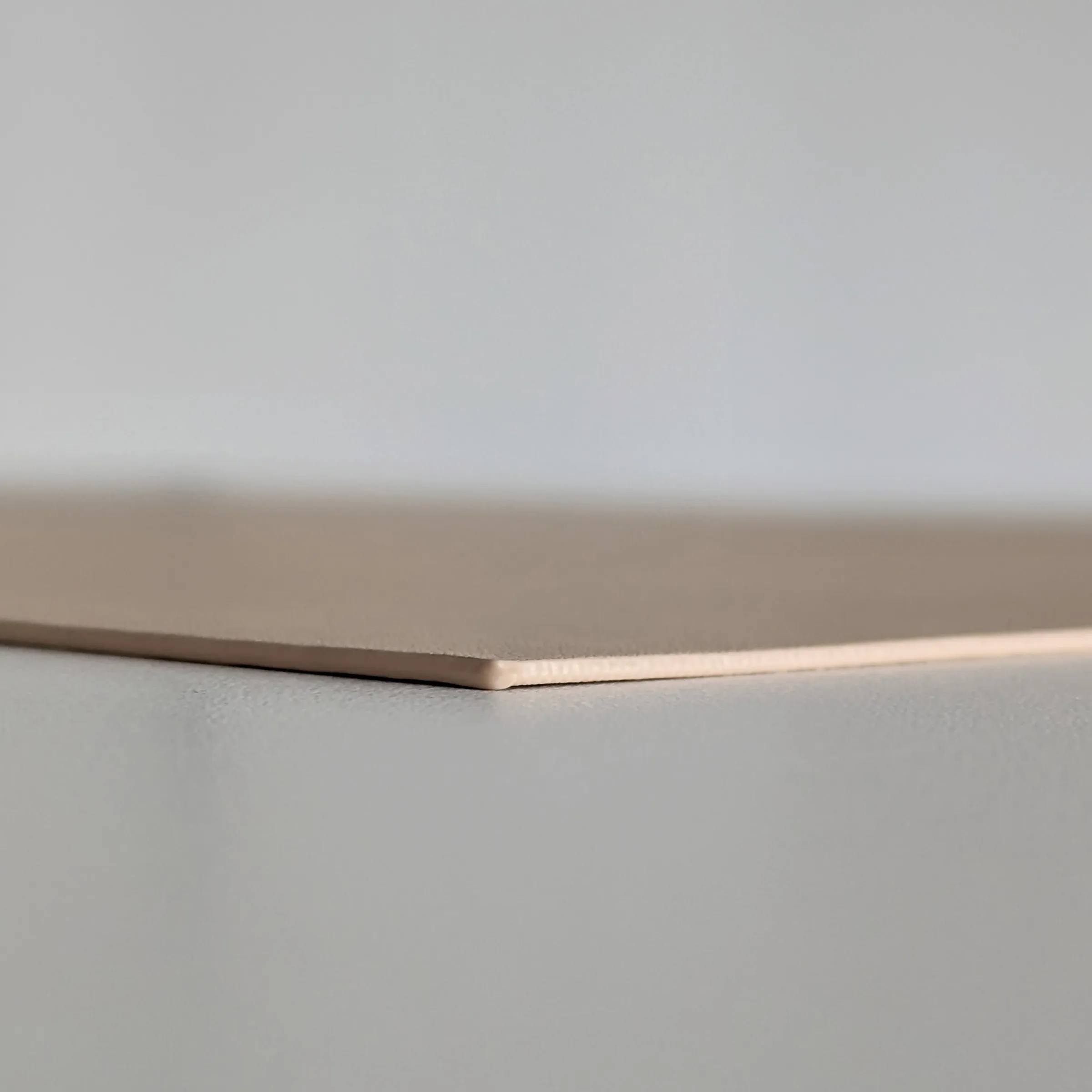 Notizblock Papier Design minimalistisch Graubeige Notizblock oder Schreibblock aus Papier, angewinkelt auf grauer Oberfläche fotografiert