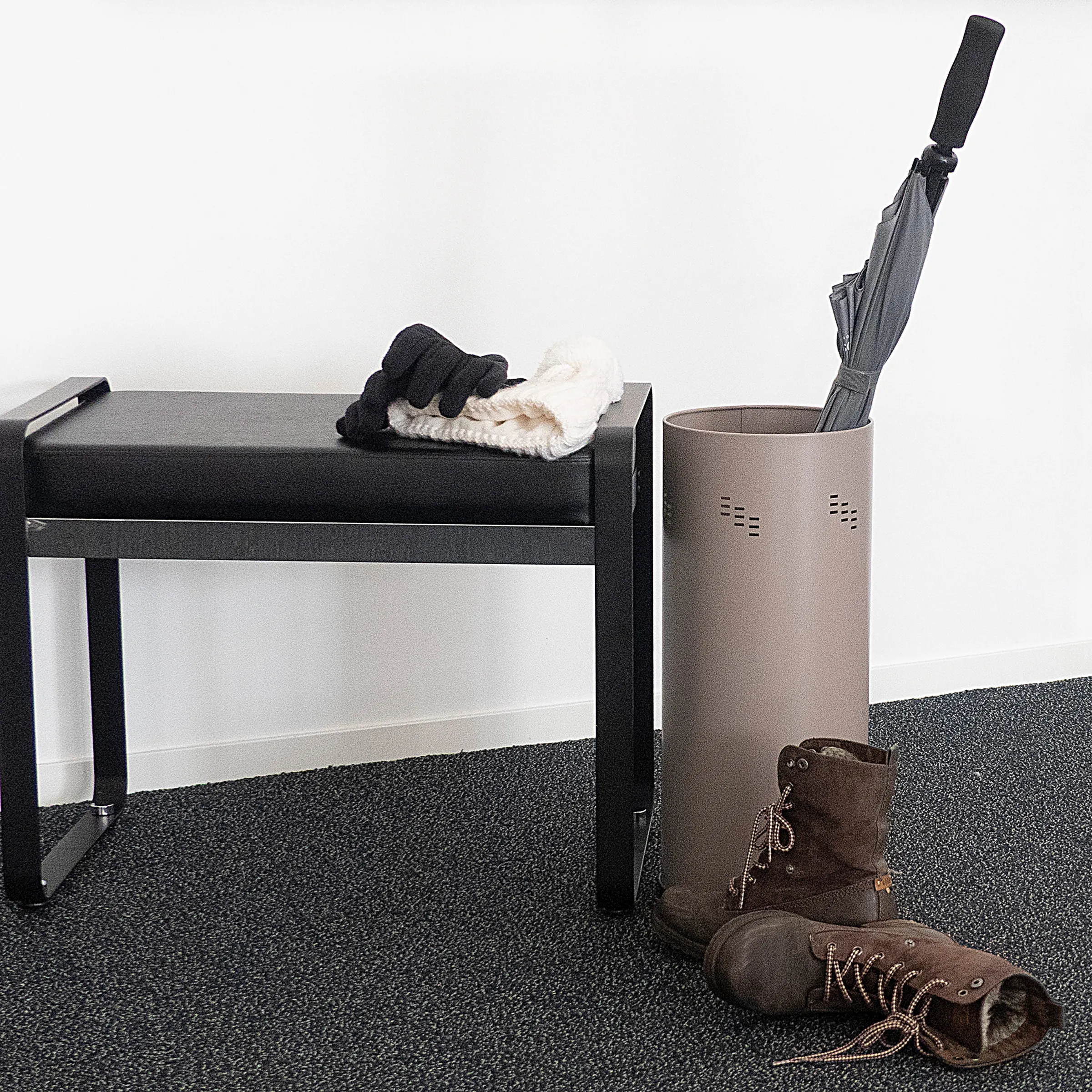 Flur Garderobe Set mit Sitzbank und Schuhständer Modernes Flur-Set mit schwarzer Sitzbank, grauem Regenschirmständer und Schuhen auf dunklem Boden