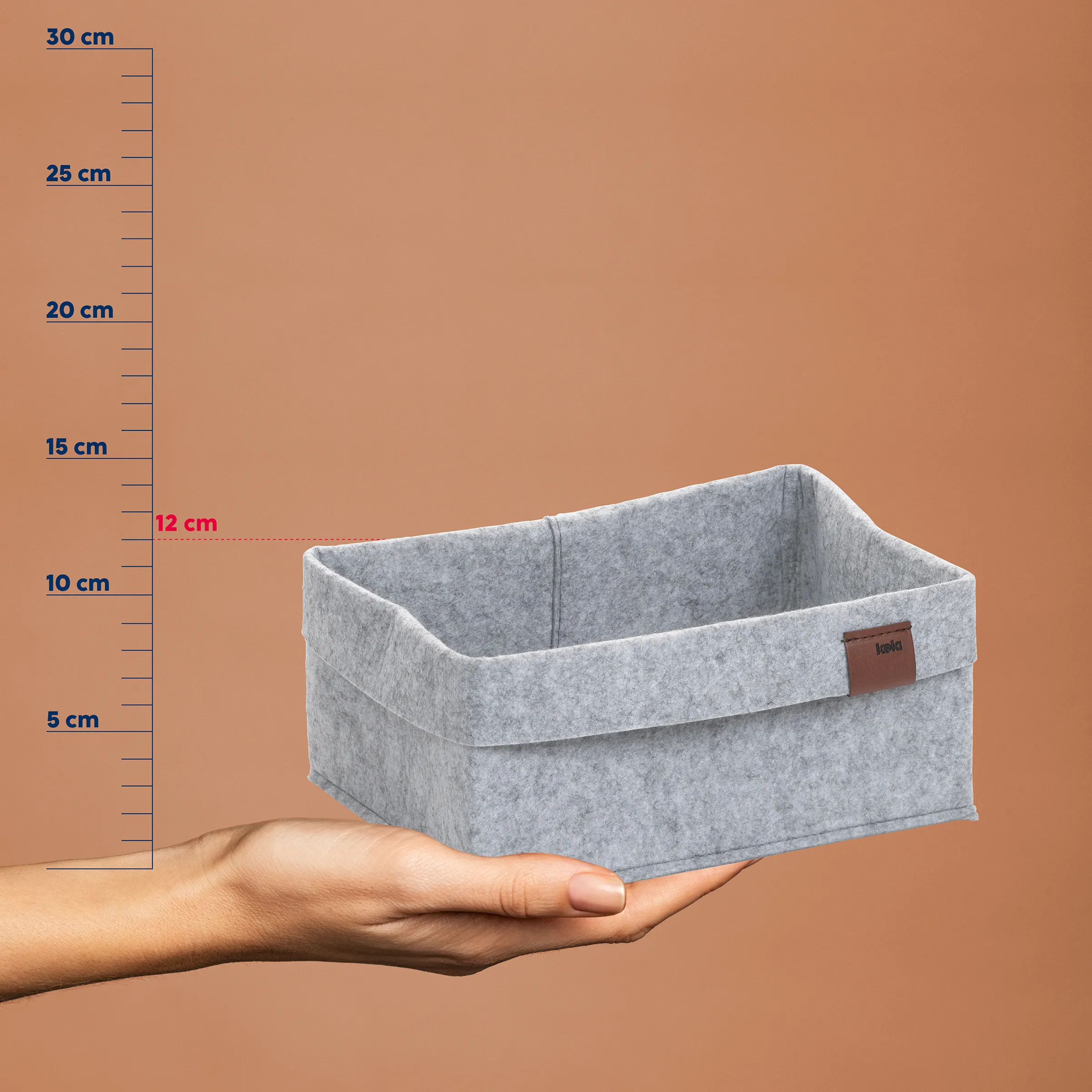 Graue Filzbox mit Henkel auf Hand vor Messskala, 12 cm Höhe markiert