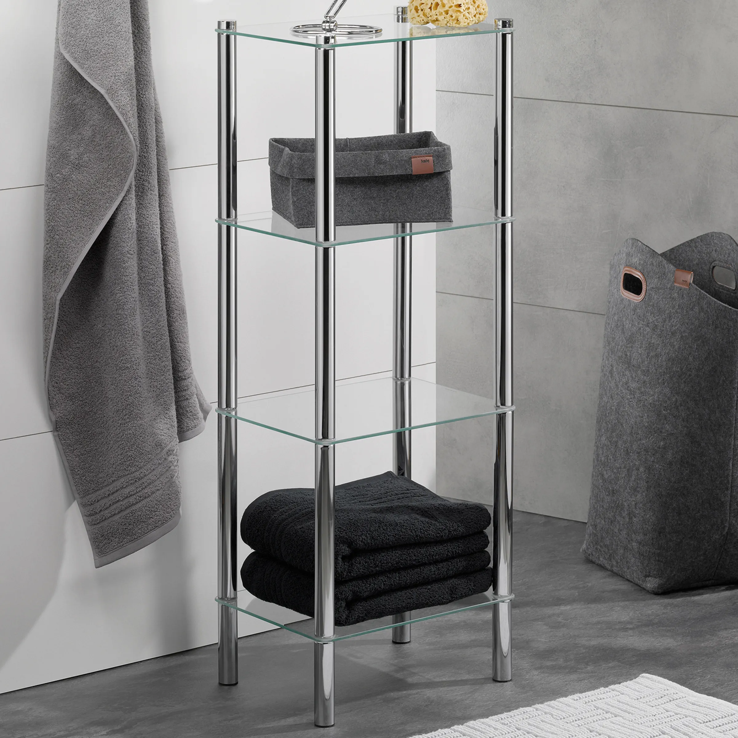 Badezimmerregal mit Glasböden - Moderne Badezimmermöbel Modernes Badezimmerregal mit vier Glasböden und Edelstahlrahmen, gefüllt mit Handtüchern und Aufbewahrungskörben