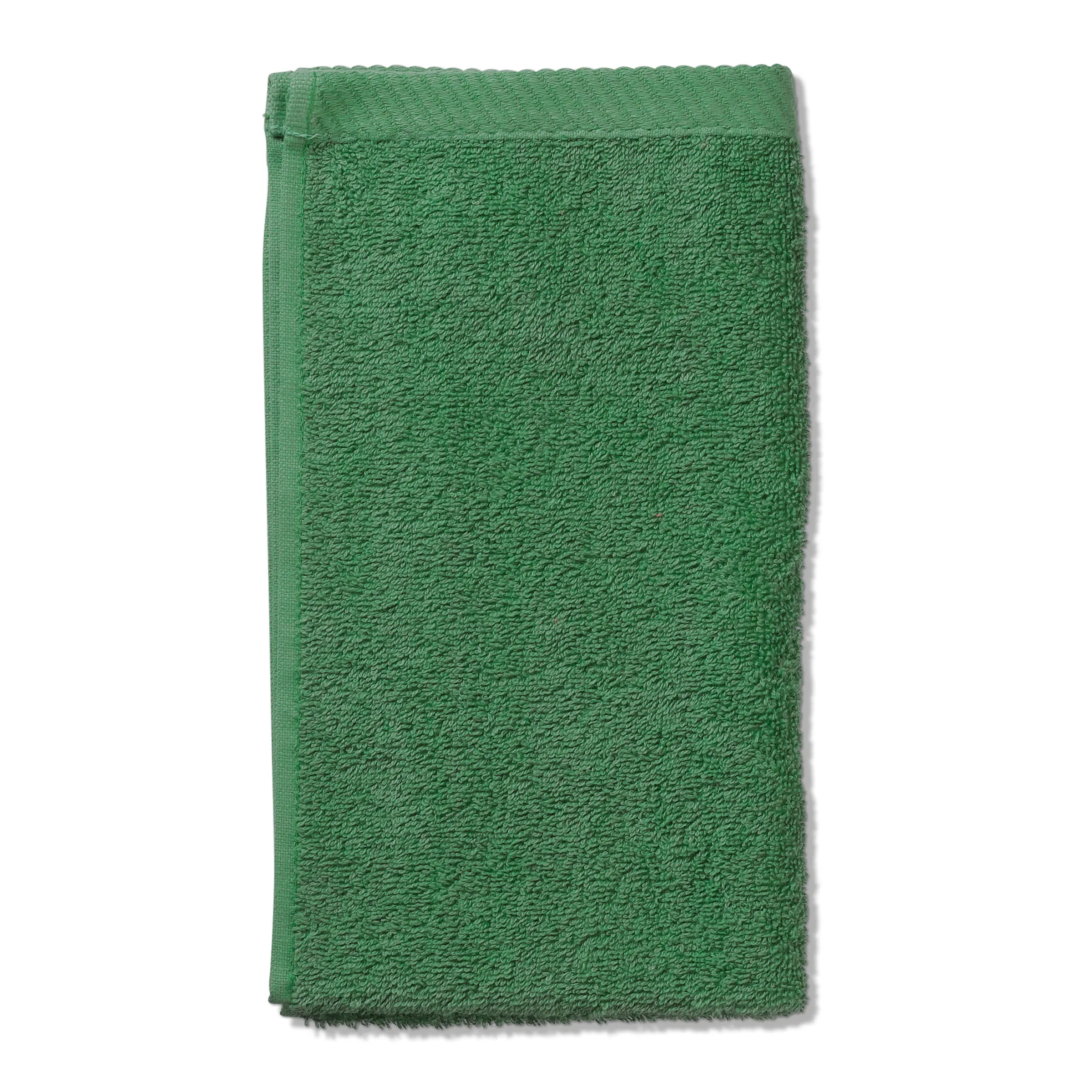 Grünes Handtuch Frottee - Premium Badtuch Grünes Frotteehandtuch mit strukturierter Oberfläche und gerafftem Saum, auf weißem Hintergrund dargestellt.