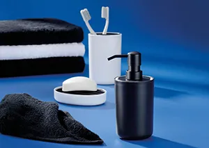 Badezimmer-Accessoires Set mit schwarzem Handtuch, weißer Zahnbürstenhalter, weißer Seifenschale und schwarzer Spender auf blauem Hintergrund.
