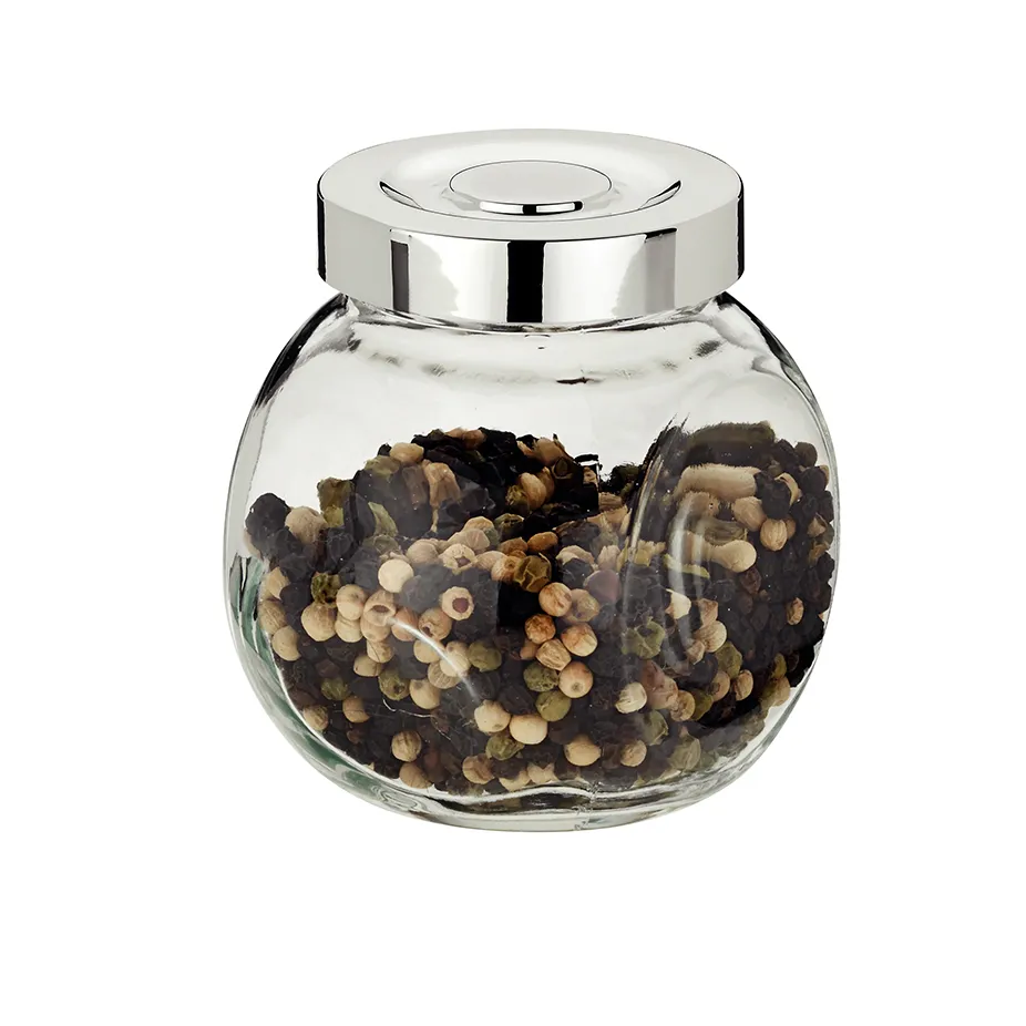 Glasdose mit Metalldeckel gefüllt mit bunten Pfefferkörnern und Gewürzen vor weißem Hintergrund