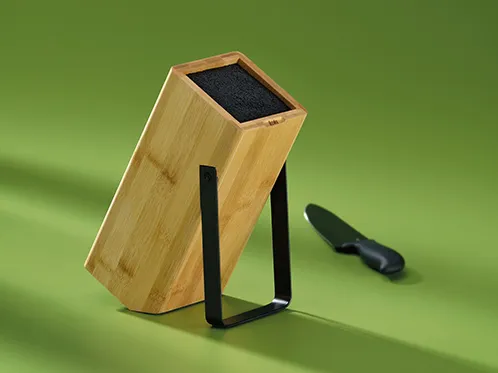 Messerblock Holz mit Schleifstein - Küchenzubehör Holzmesserblock mit schwarzem Schleifstein und Küchenmesser auf grünem Hintergrund