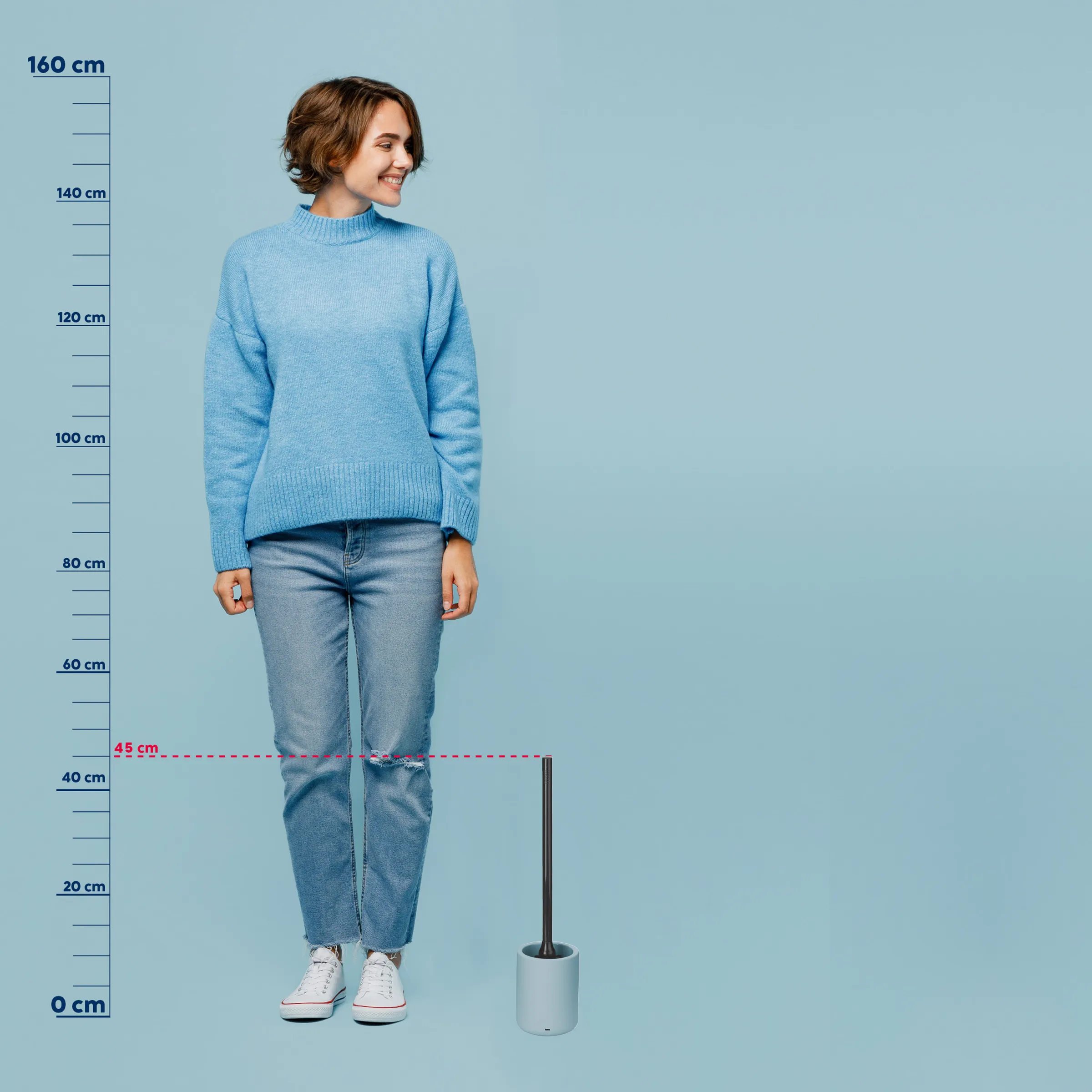 Rollkragenpullover Damen hellblau - Größenvergleich Frau mit braunem Haar in hellblauem Rollkragenpullover und blauer Jeans vor Messskala