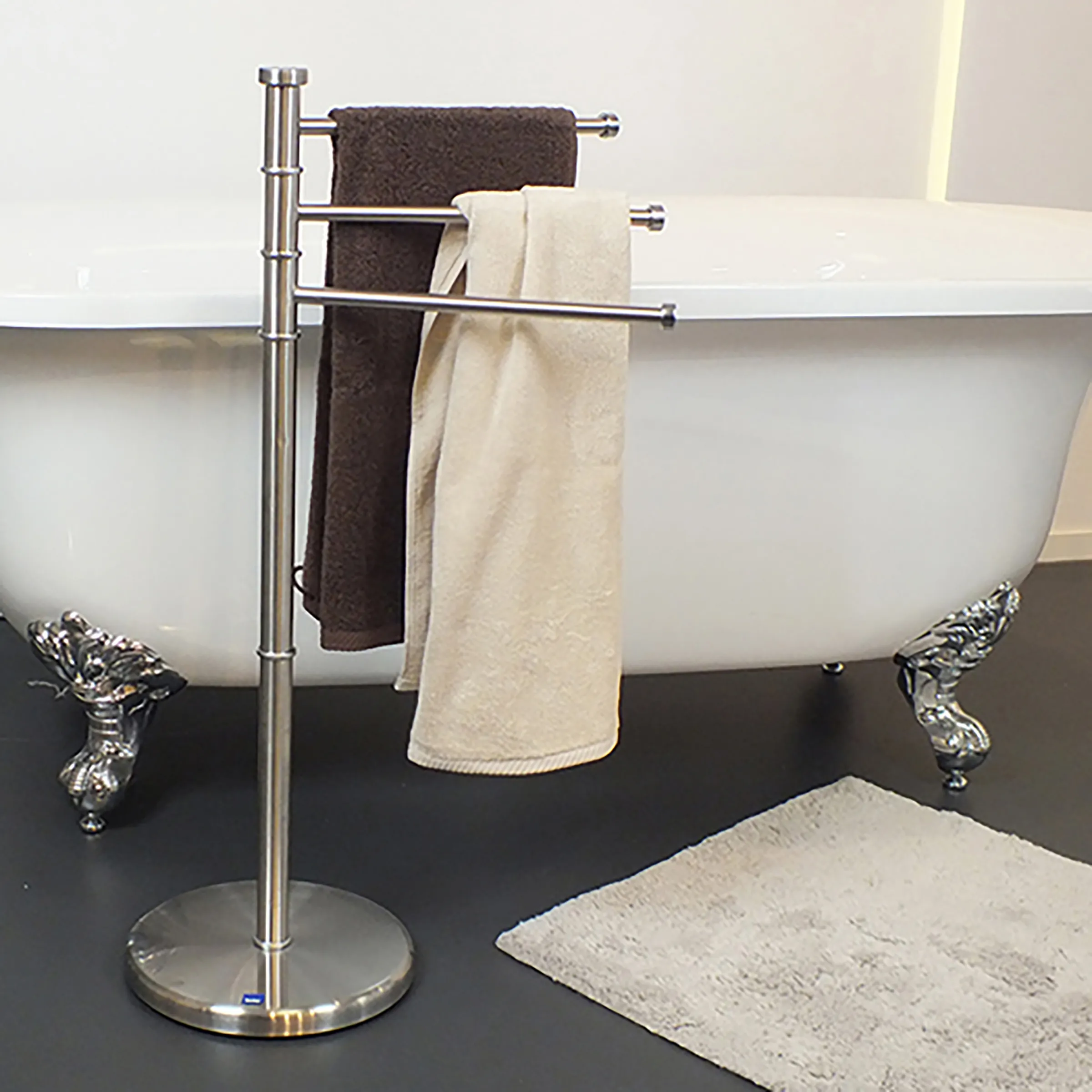 Freistehender Handtuchhalter Edelstahl Badezimmer Freistehender Handtuchständer aus Edelstahl mit drei Stangen, beladen mit braunen und beigen Handtüchern neben einer Badewanne.