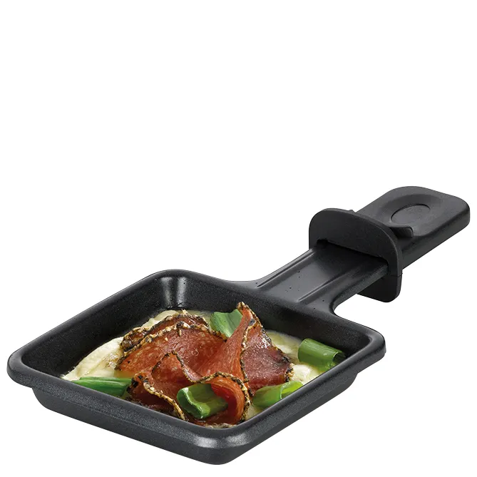 Kleine schwarze Raclette-Pfanne mit Griff, gefüllt mit Fleisch, Gemüse und Käse
