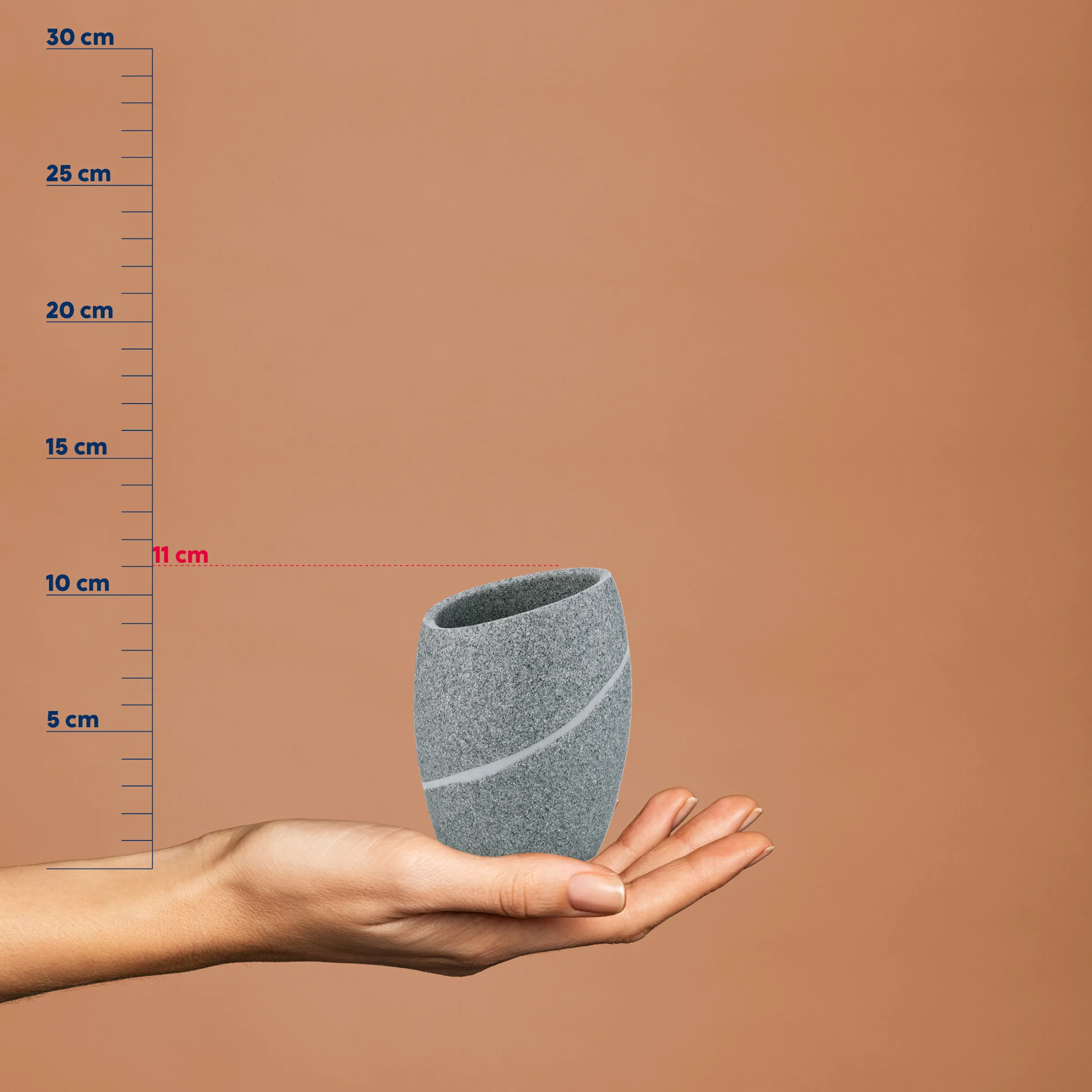 Kleine graue Betonvase mit weißem Streifen in einer Hand vor Messstab, etwa 11 cm hoch