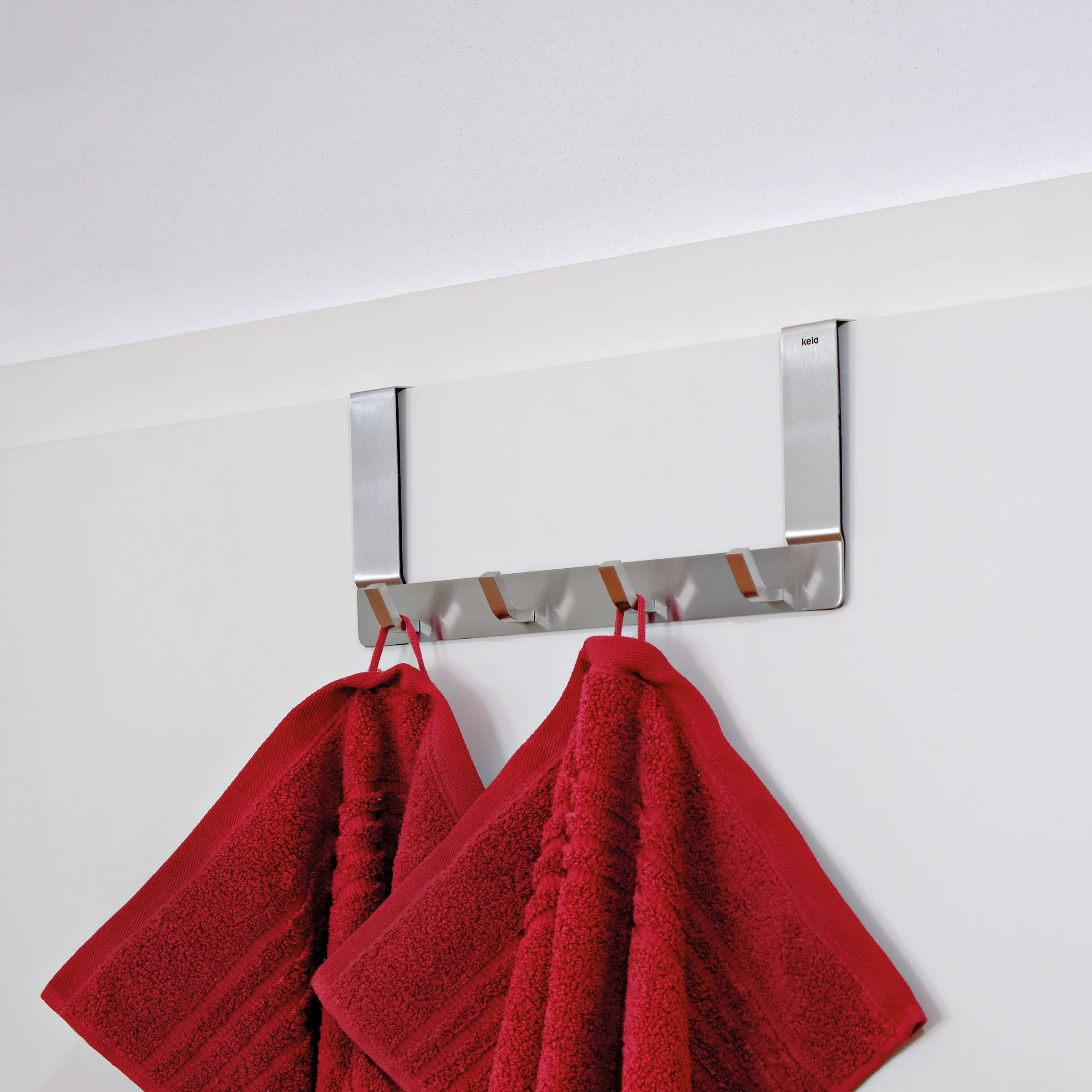 Moderne Handtuchleiste aus Edelstahl mit zwei silbernen Bügeln und grauem Mittelsteg, an der zwei rote Handtücher hängen.