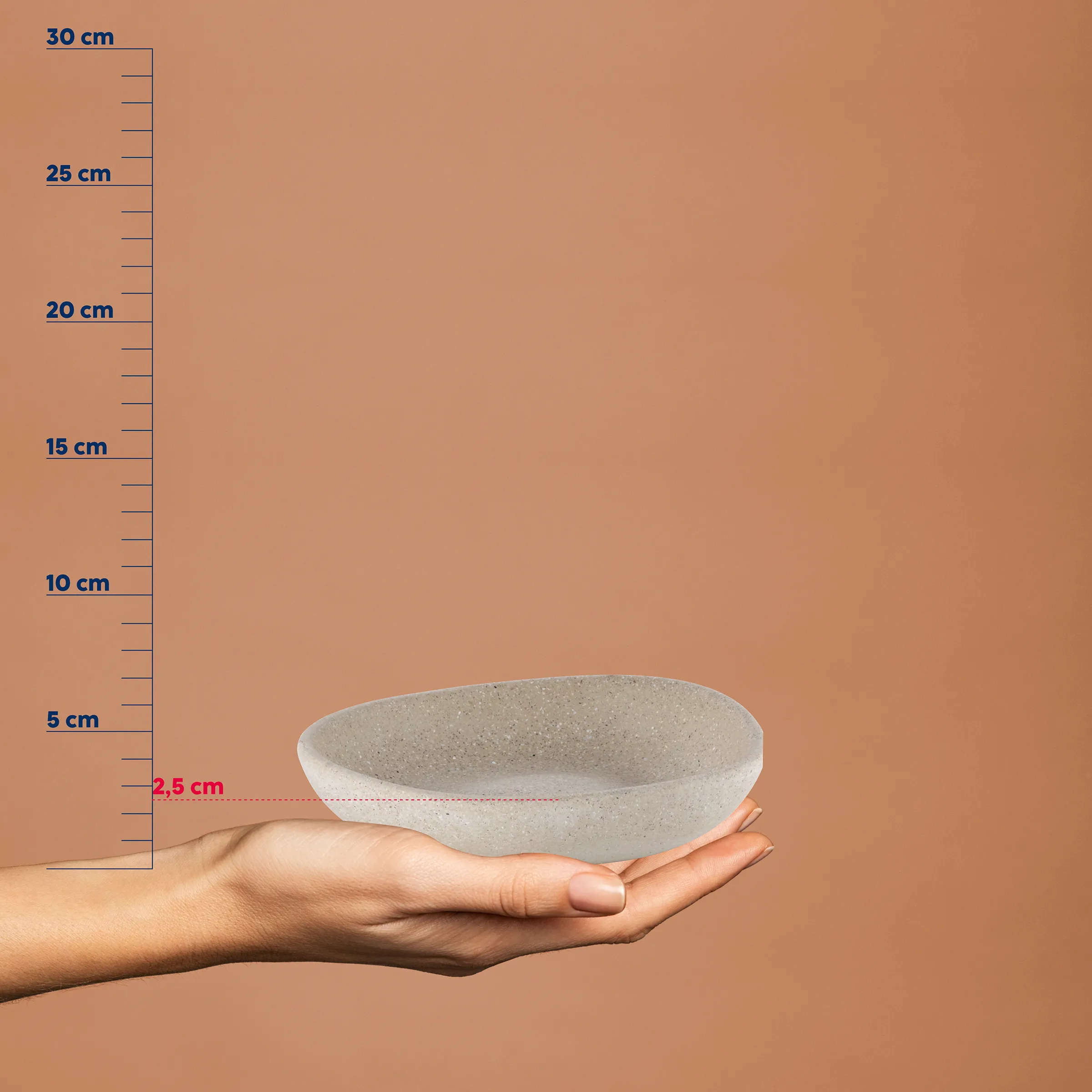 Kleine Steinschale aus Beton - dekorative Schale Kleine graue Steinschale in einer Hand, neben einer Messskala. Höhe etwa 2,5 cm, oval geformtes Tablett.
