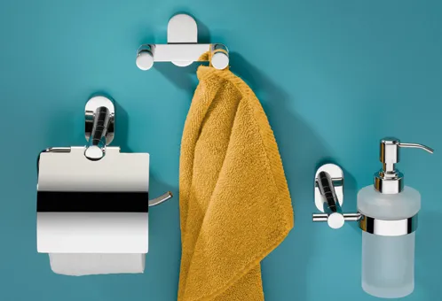 Modernes Badezimmer-Set mit weißen Accessoires und goldgelbem Handtuch an türkisem Hintergrund