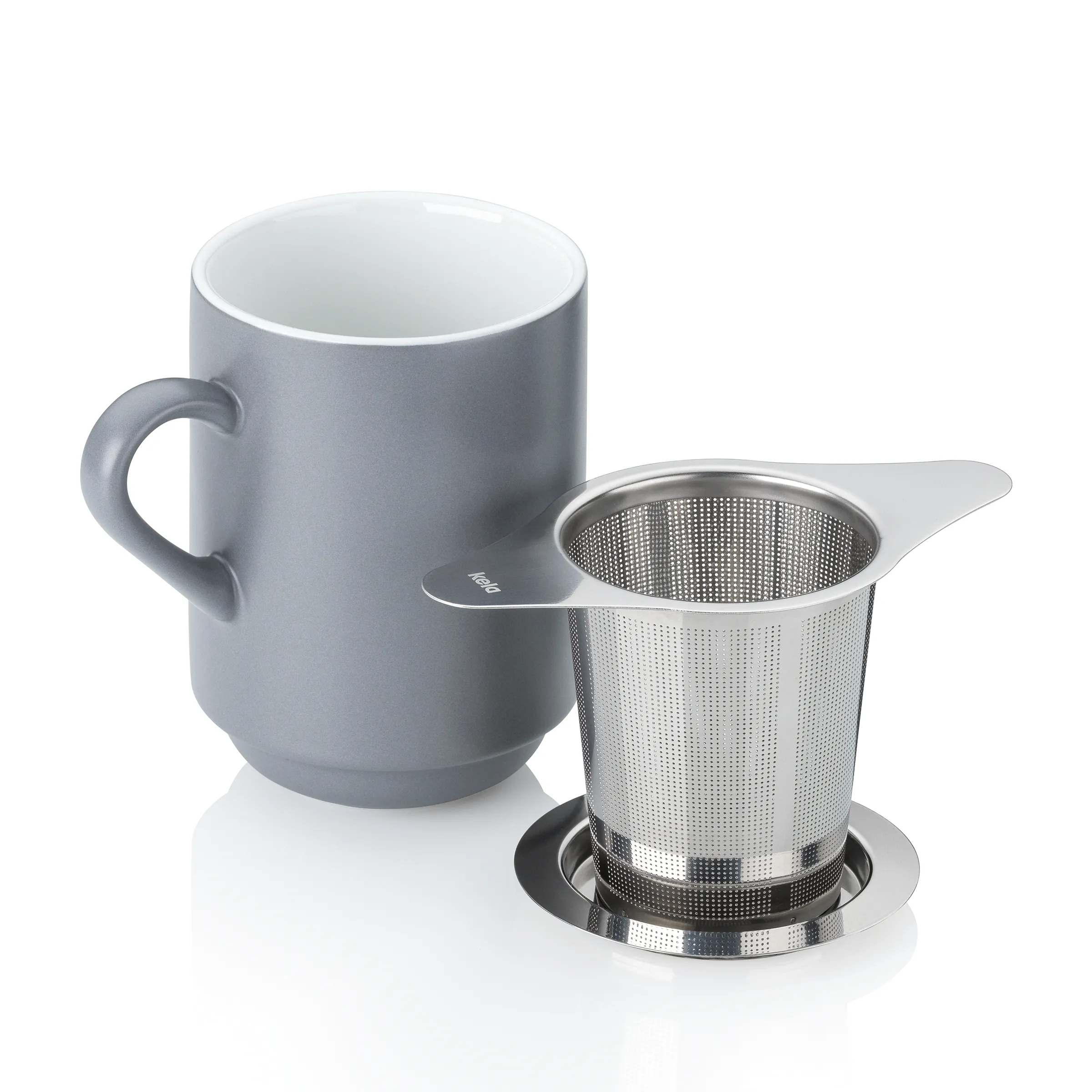 Graue Keramiktasse mit Henkel und silbernes Teesieb mit Griff auf weißem Hintergrund