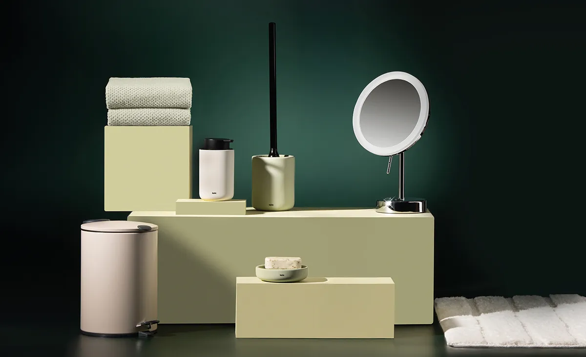Badezimmer-Accessoires Set mit Handtüchern, Spiegeln, Behältern und Dekorationsgegenständen in Pastellfarben auf grünem Hintergrund