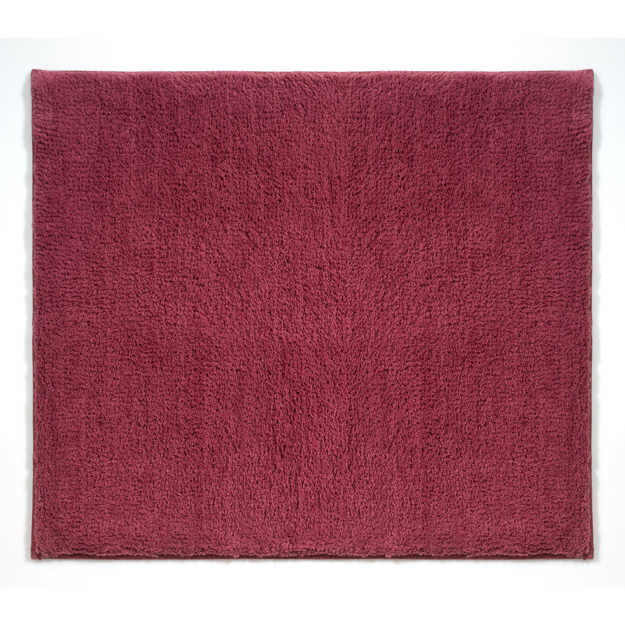 Weiche Badematte in Bordeauxrot mit flauschiger Hochflor-Oberfläche auf weißem Hintergrund
