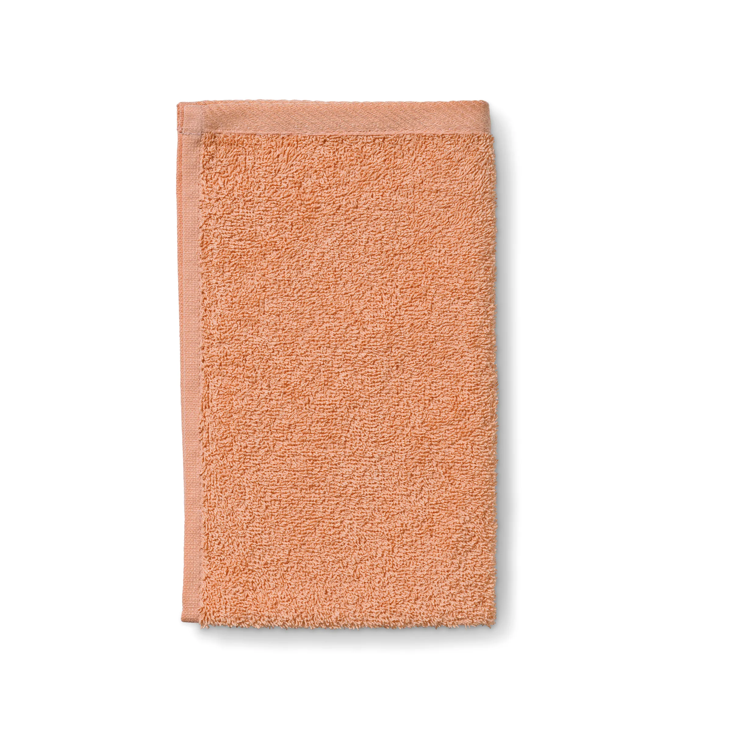 Frottee-Handtuch apricot - Premium Baumwolle Apricot-farbenes Frottee-Handtuch mit strukturierter Oberfläche und gewebtem Rand, isoliert auf weißem Hintergrund.