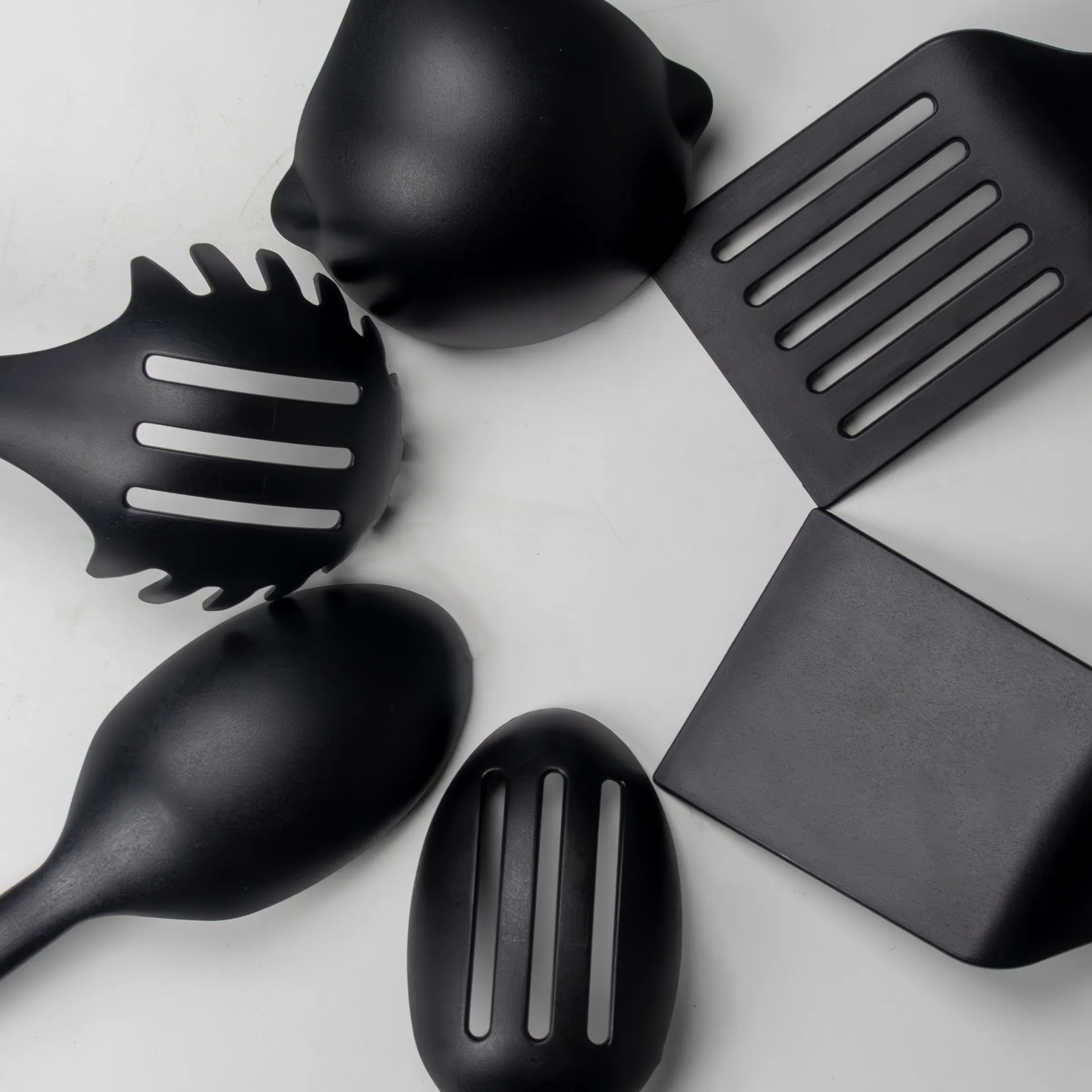 Küchenutensilien Set - 5-teiliges Kochbesteck aus Kunststoff Satz schwarzer Küchenutensilien: Ladle, Kochlöffel, Schaber, Servierlöffel und Spatel auf weißem Hintergrund