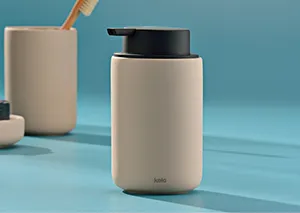 Beige Thermoskanne mit schwarzem Deckel auf blauem Hintergrund neben minimalistischen Accessoires