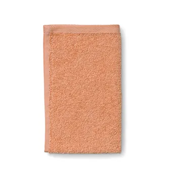 Apricot-farbenes Frottee-Handtuch mit strukturierter Oberfläche und gewebtem Rand, isoliert auf weißem Hintergrund.