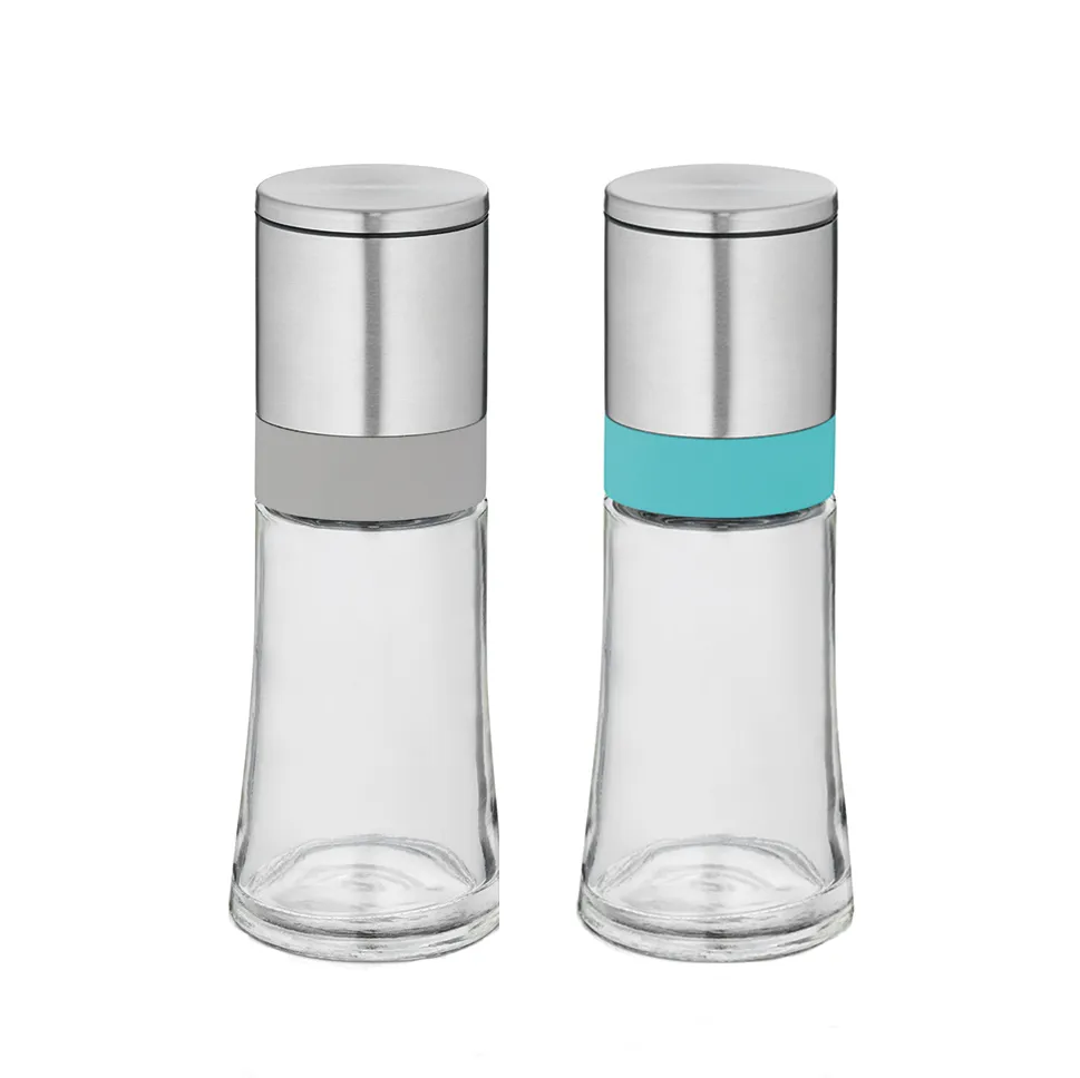 Zwei Gewürzmühlen aus Glas und Edelstahl mit Metalldeckel. Eine ist leer, die andere mit blauer Flüssigkeit gefüllt.