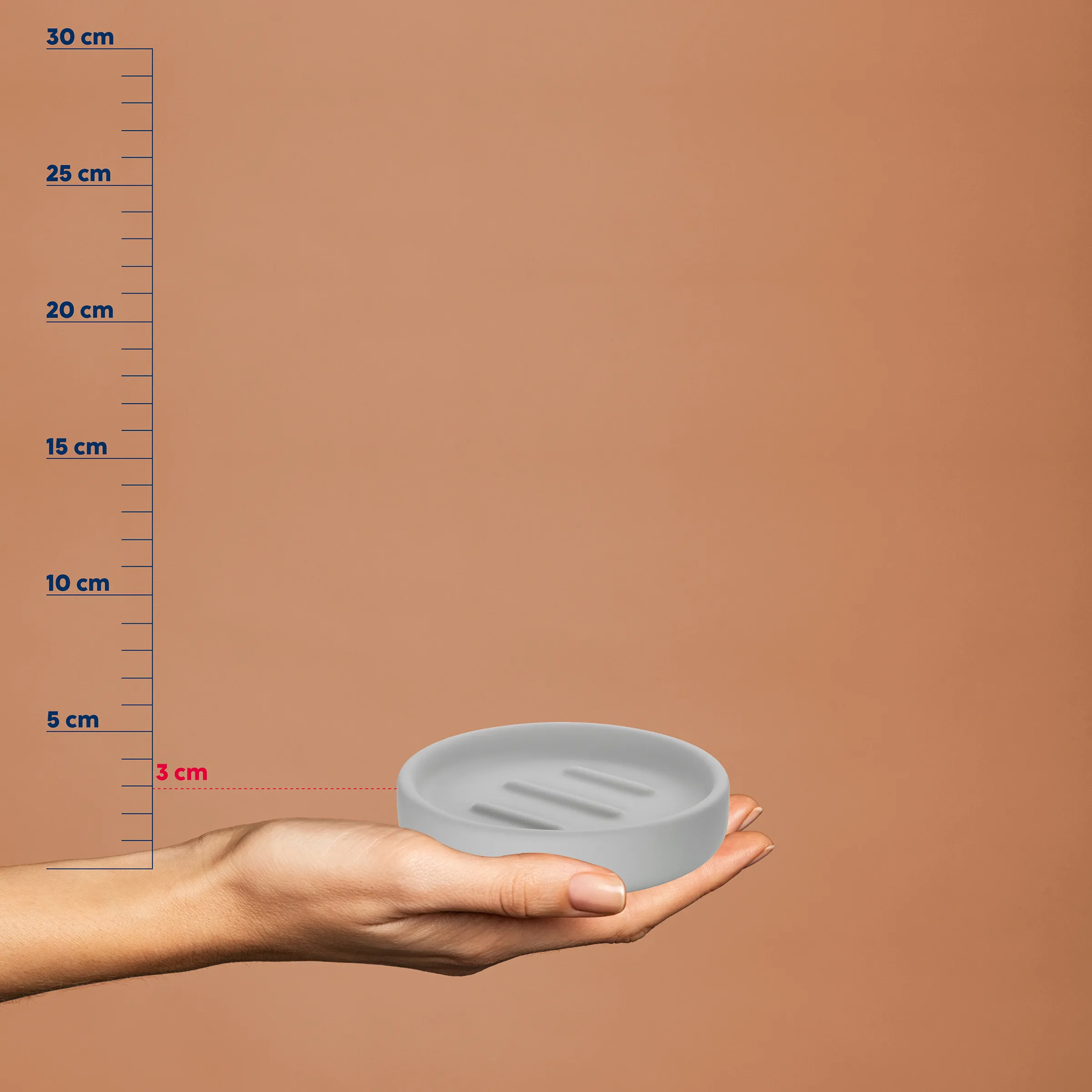 Hand hält eine graue Seifenschale mit Rillen. Maßstab zeigt eine Höhe von etwa 3 cm.