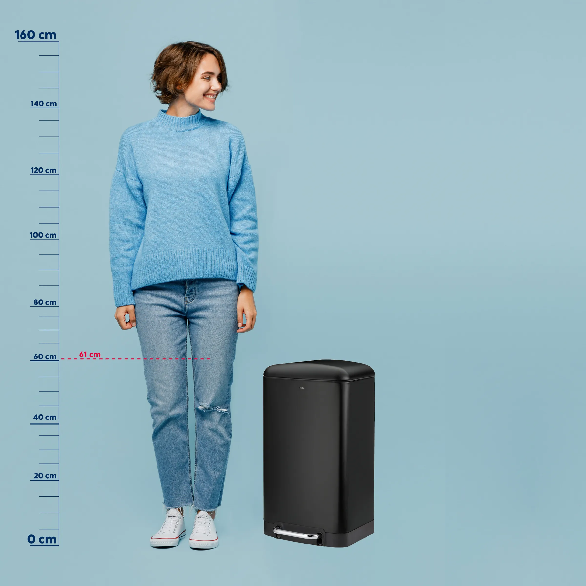 Schwarzer Treteimer 61 cm - Abfalleimer mit Fußpedal Größenvergleich Schwarzer Treteimer 61 cm hoch neben Frau in blauem Pullover, Größenvergleich mit Maßstab bis 160 cm