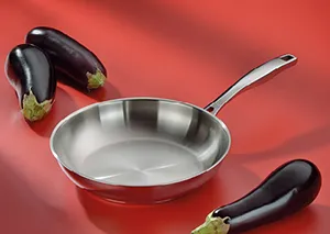 Edelstahl-Bratpfanne mit Auberginen - Professionelles Kochgeschirr Edelstahl-Bratpfanne mit langem Griff und zwei Auberginen auf rotem Hintergrund