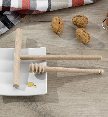 Holz-Nussknacker-Set mit weißem Mörser, Holzstößel, Nussknacker und drei ganzen Mandeln auf Holztisch
