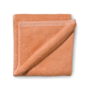 Zwei gefaltete Frotteetücher in warmem Apricot-Orange übereinander gelegt auf weißem Hintergrund