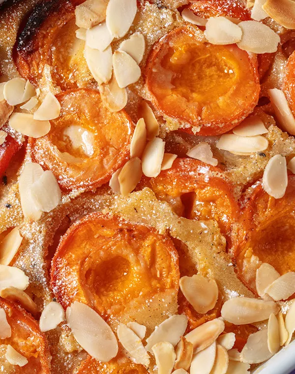 Mandelgebäck mit Puderzucker - köstliche Backwaren Appetitliche Gebäckteilchen mit goldbrauner Glasur, Puderzucker und Mandelblättchen als Dekoration