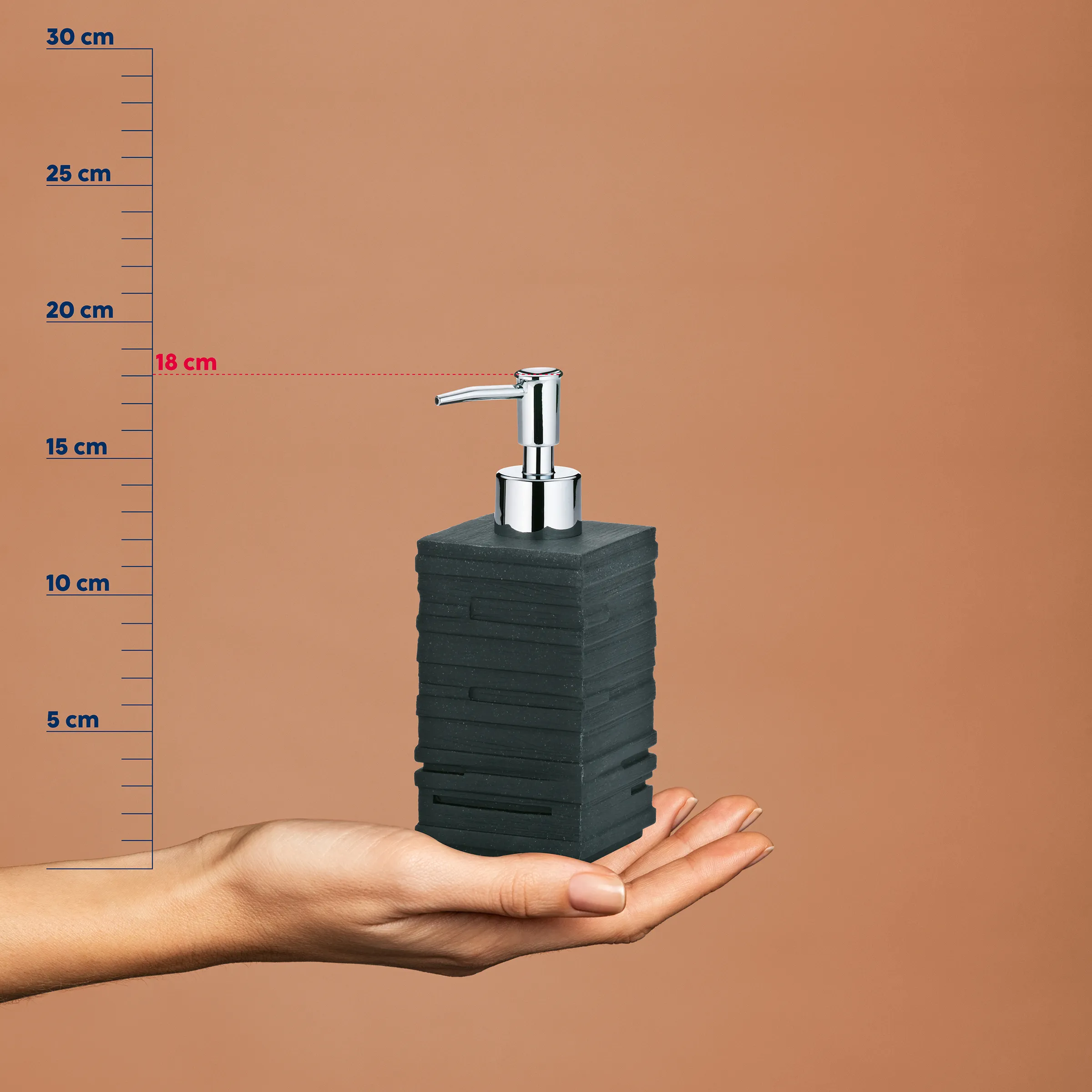 Seifenspender Stein mit Dosierpumpe kaufen Seifenspender mit schwarzem Steinbehälter und Chromdispenser wird in einer Hand gehalten, vor Messskala