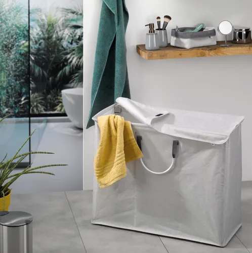 Wäschekorb weiß - Waschkorb für Badezimmer Wäschekorb weiß mit gelben und grünen Handtüchern im modernen Badezimmer mit Holzablage