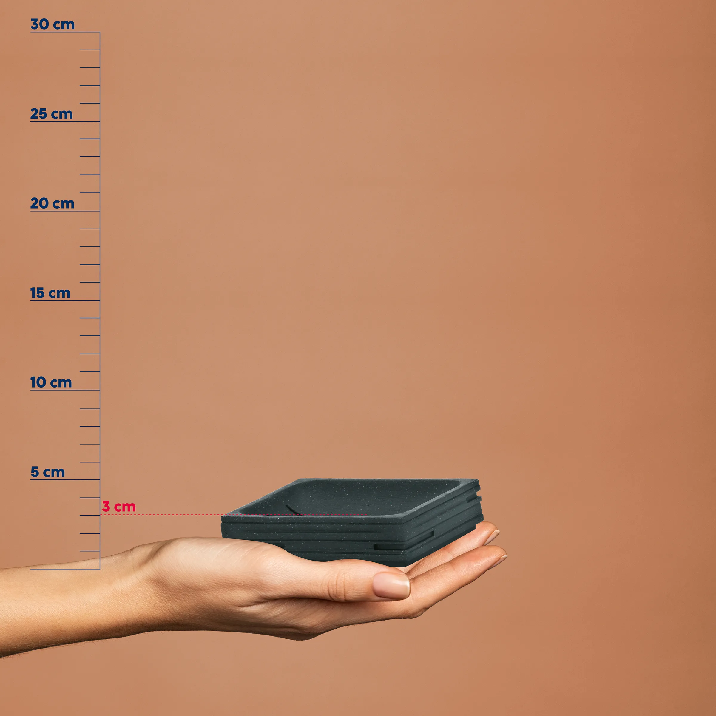 Stapelbare Behälter klein kompakt Lagerung Hand hält schwarze stapelbare Behälter neben Messskala, Höhe etwa 3 cm