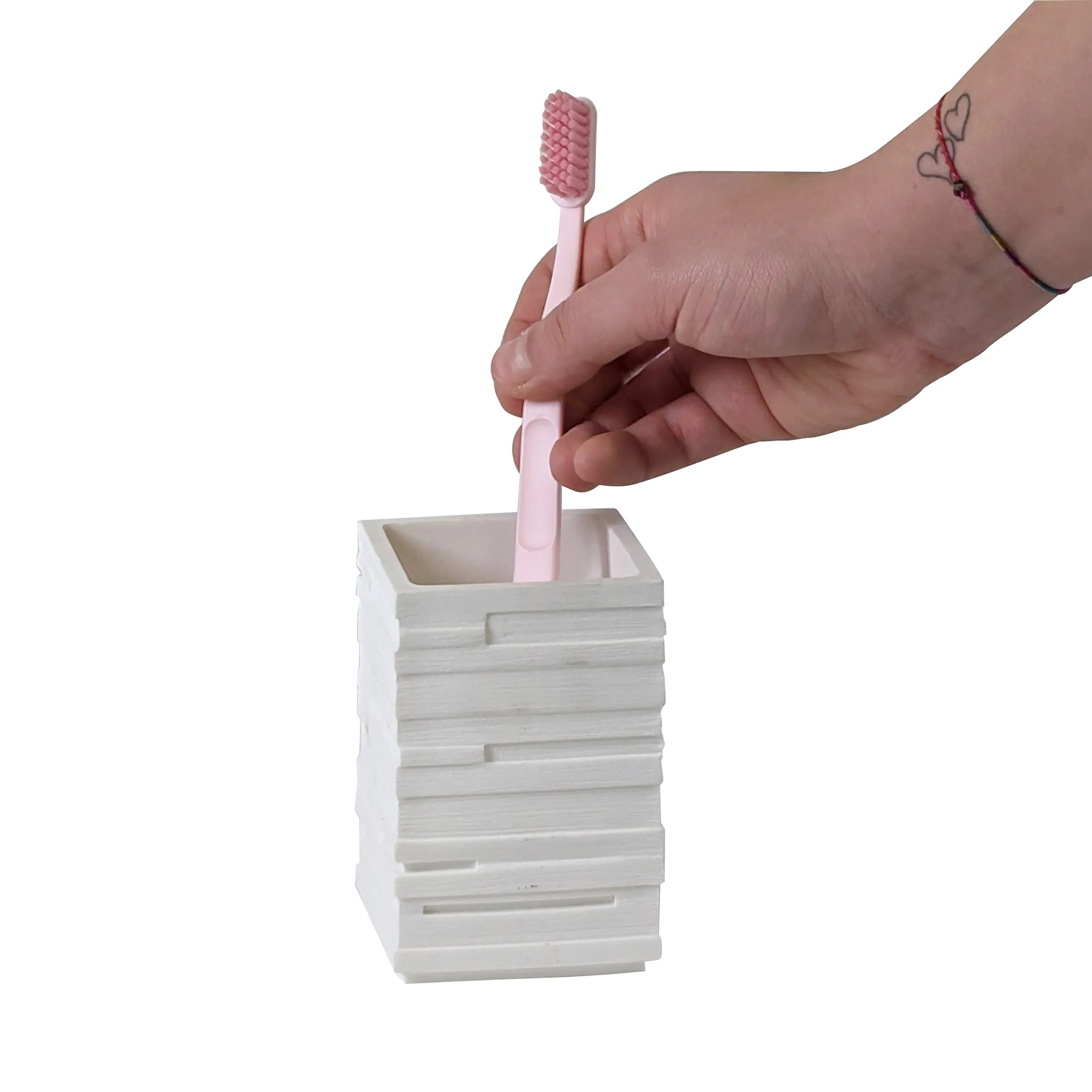 Zahnbürsten-Halter weiß - modernes Badezimmer-Accessoire Hand hält pink Zahnbürste über weißem Zahnbürsten-Behälter mit horizontalen Rillen