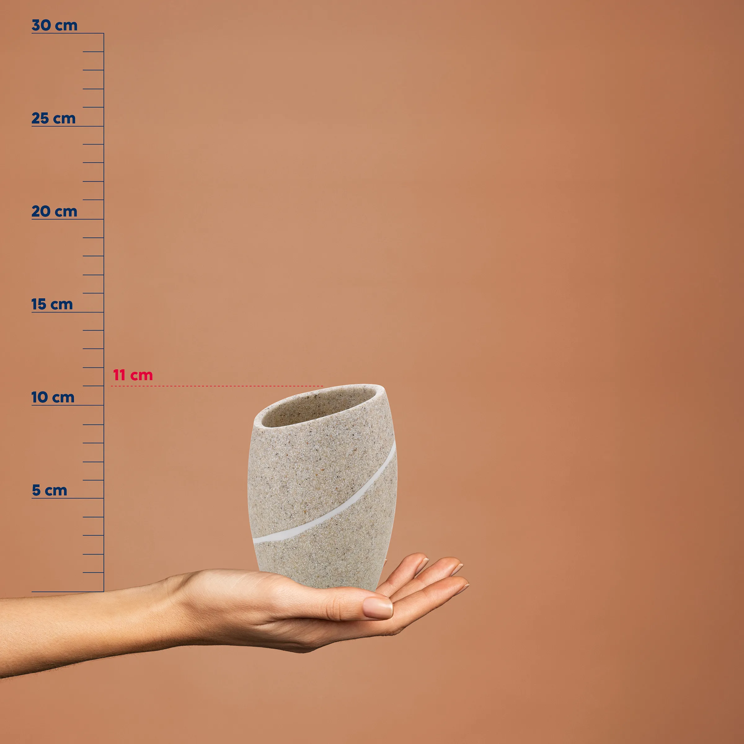 Kleine beige Betonvase mit weißem Streifen in einer Hand, vor Maßstab mit 11 cm Höhe markiert