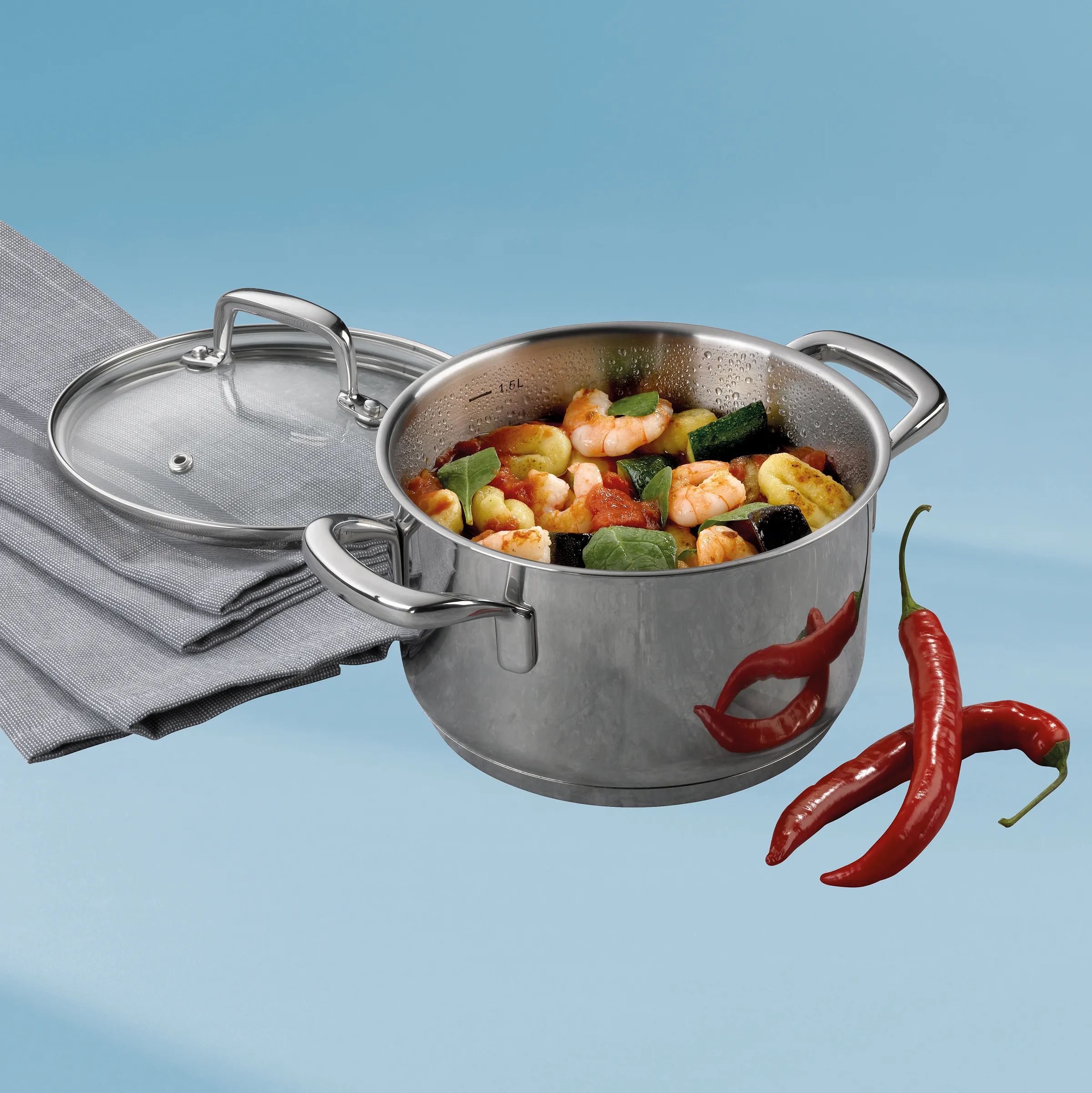 Edelstahl-Kochtopf mit Glasdeckel für Garnelen und Gemüse Edelstahl-Kochtopf mit Glasdeckel gefüllt mit Garnelen und Gemüse, daneben rote Chilischoten