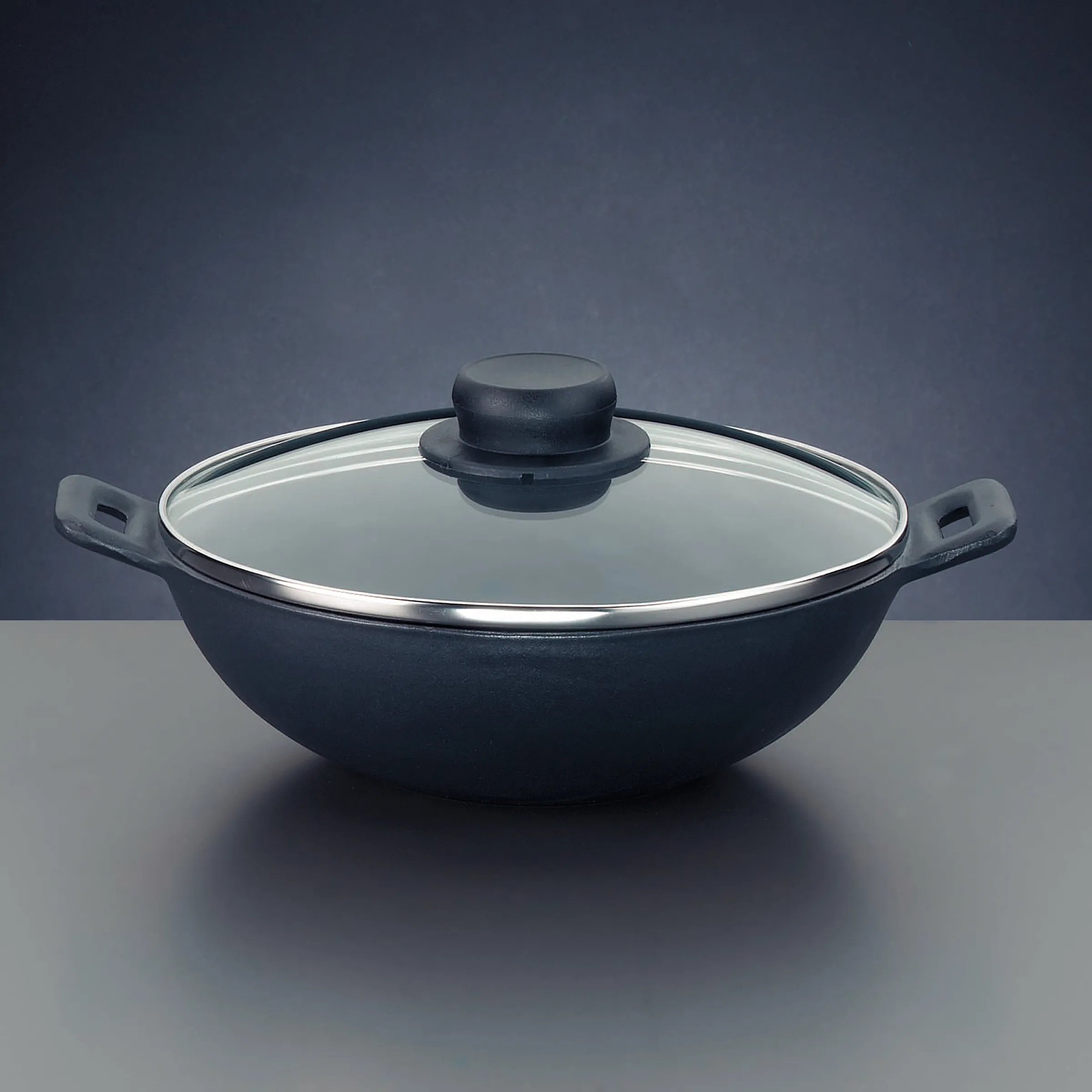 Wok-Pfanne mit Glasdeckel - Antihaftbeschichtete Pfanne mit Deckel Schwarze Wok-Pfanne mit Glasdeckel und zwei seitlichen Griffen auf grauem Hintergrund