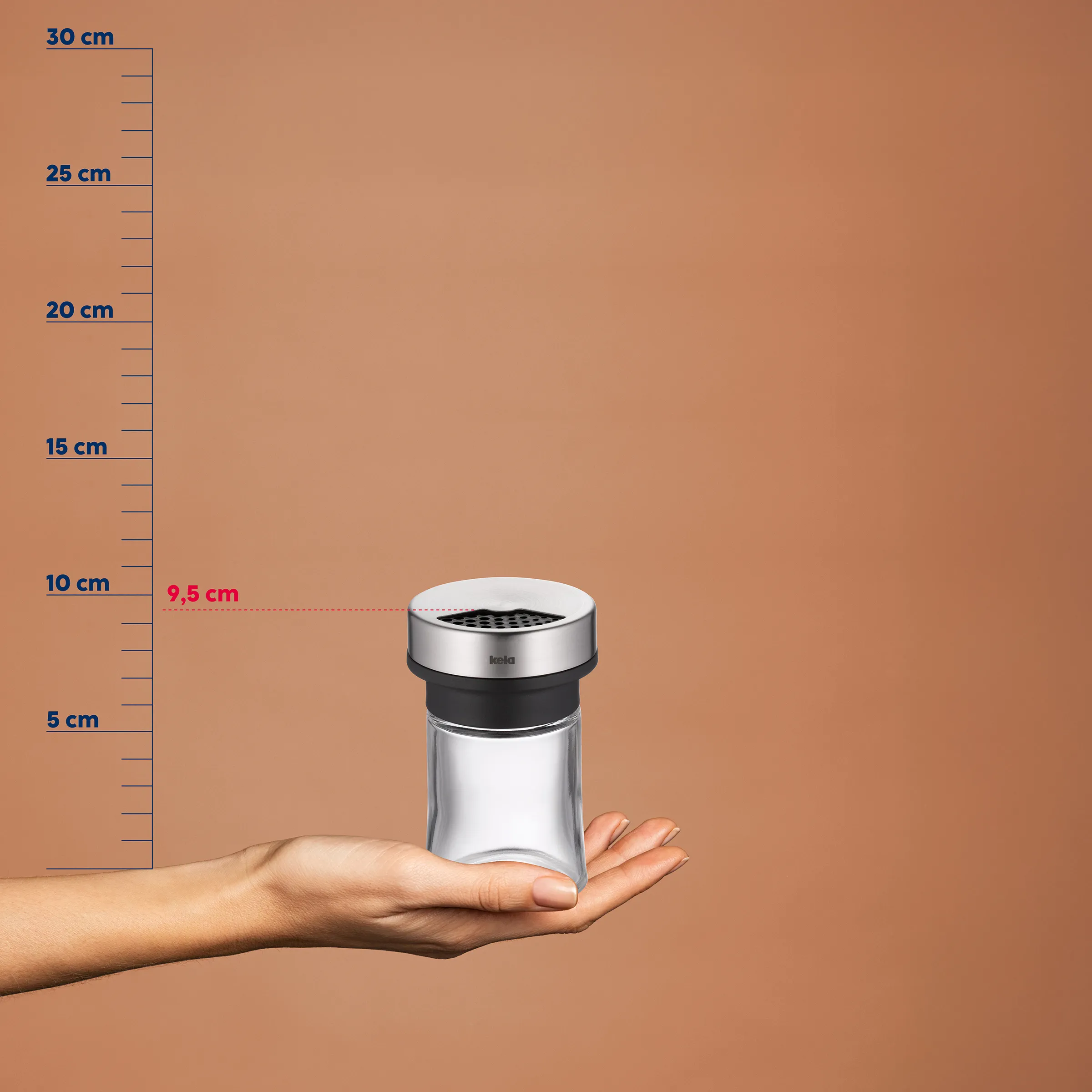 Kräuterstreuer Edelstahl kompakt 9,5 cm Kompakte Kräuterstreuer mit silbernem Gehäuse und schwarzem Streudach auf einer Hand vor Größenlehre mit 9,5 cm Durchmesser