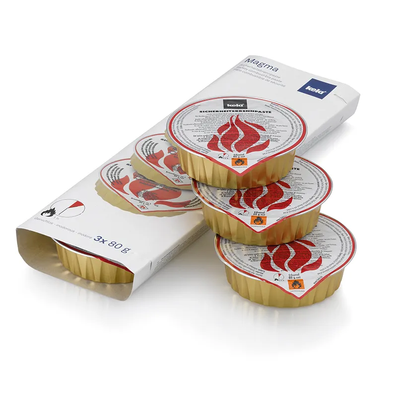 Magma Sicherheitsschrumpfpaste 3x60g Aluminium-Schalen Packung mit drei goldenen Aluminium-Schalen mit rotem Flammen-Logo und Sicherheitsschrumpffolie, daneben weiße Verpackung.