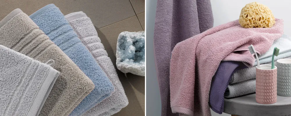 Frottee Handtücher Set Premium Baumwolle Stapel von bunten Frottee-Handtüchern in Weiß, Blau, Beige und Grautönen mit strukturiertem Muster