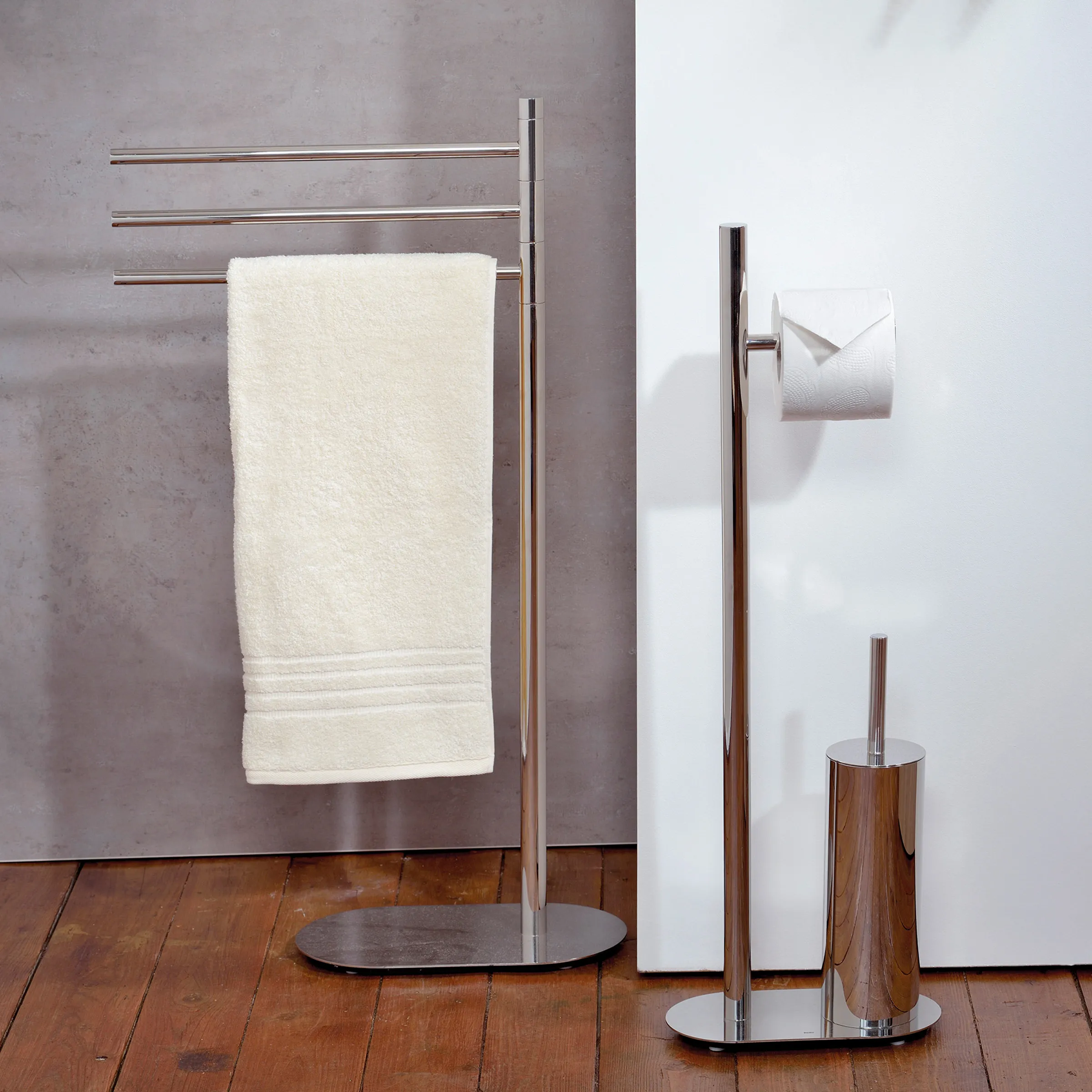 Badezimmer-Accessoires Set Edelstahl Handtuchhalter Modernes Badezimmer-Set mit Edelstahl-Handtuchhalter, Toilettenbürste und Papierhalter auf Holzboden.
