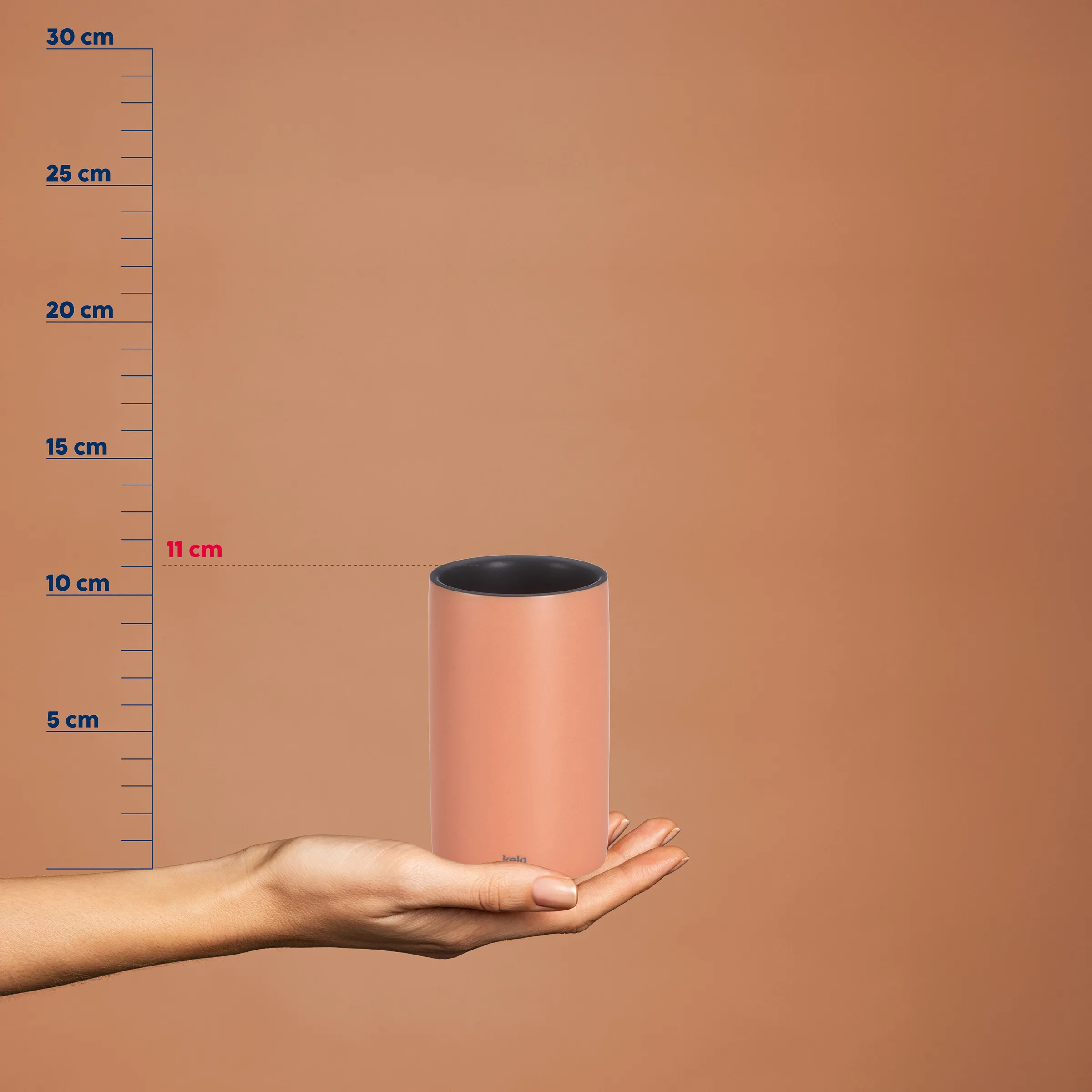 Rosafarbener Thermobecher 11 cm - Isolierbecher mit Größenskala Hand hält rosafarbenen Thermobecher mit schwarzem Inneren, Höhe 11 cm, vor Messskala