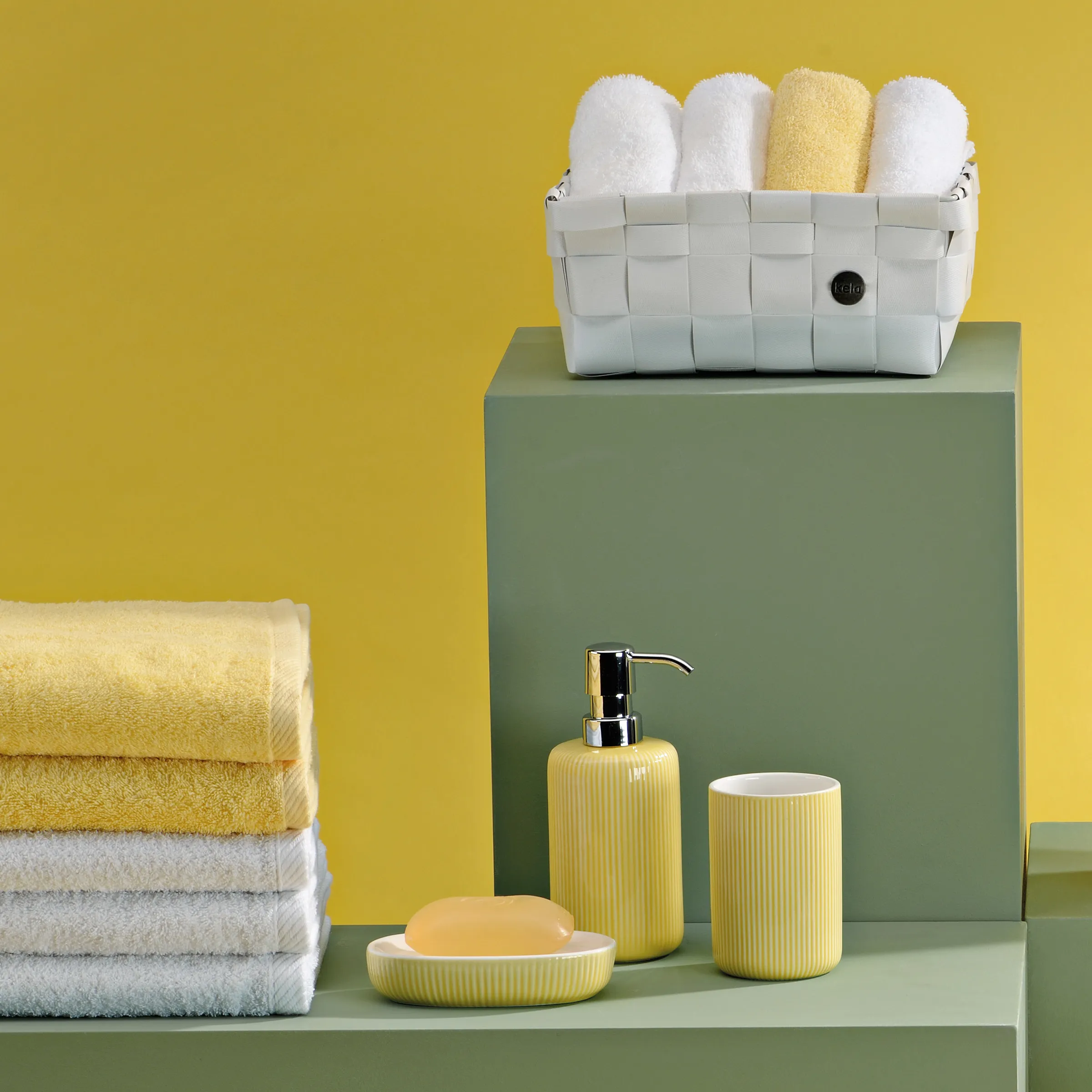 Badezimmer-Set mit gelbem und weißem Farbschema: Handtücher, Seifenspender, Zahnbürstenhalter und Aufbewahrungskorb