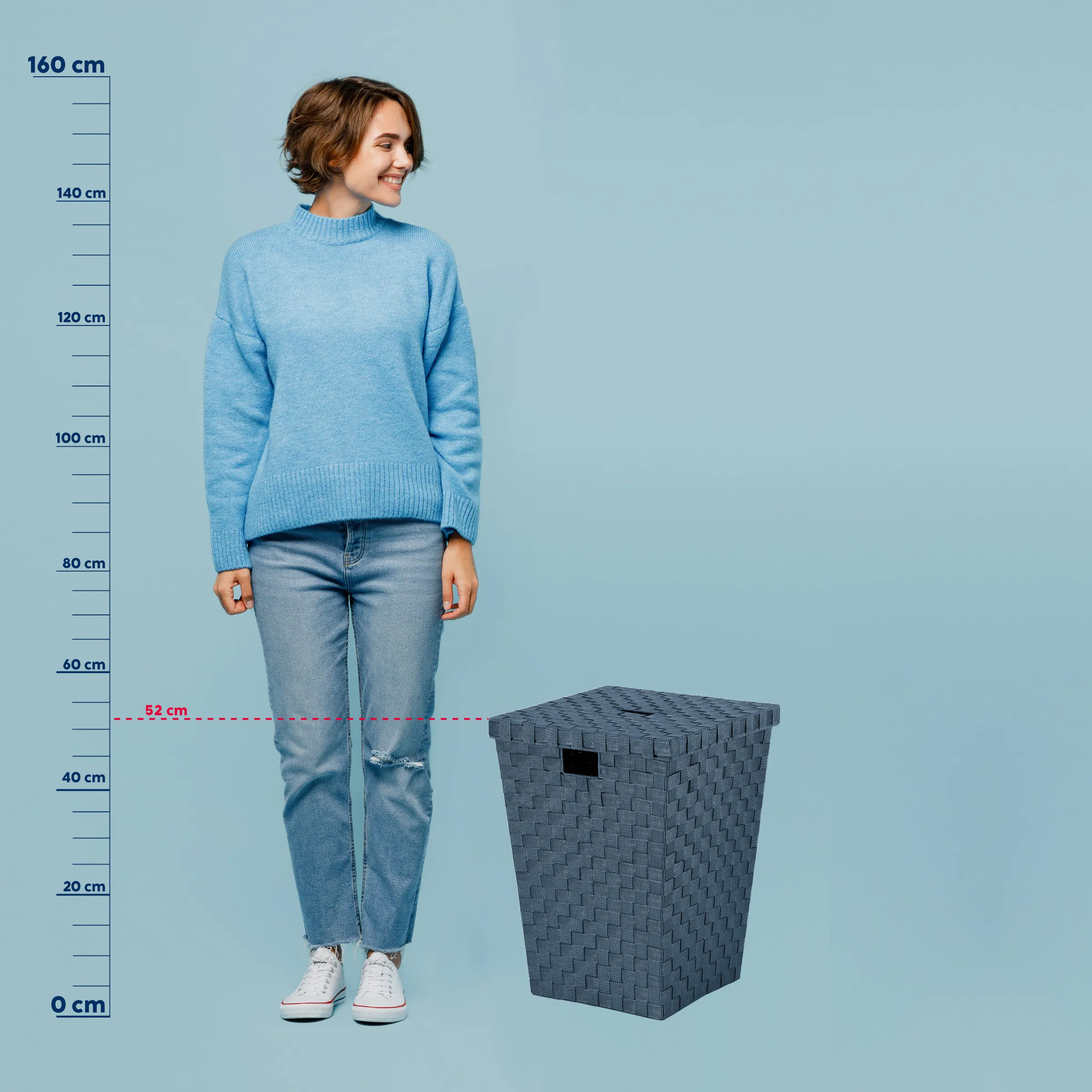 Wäschekorb Größe Vergleich - Aufbewahrungsbox Maße Frau in blauem Strickpullover und Jeans neben grauem Wäschekorb mit Größenvergleich von 52 cm Höhe