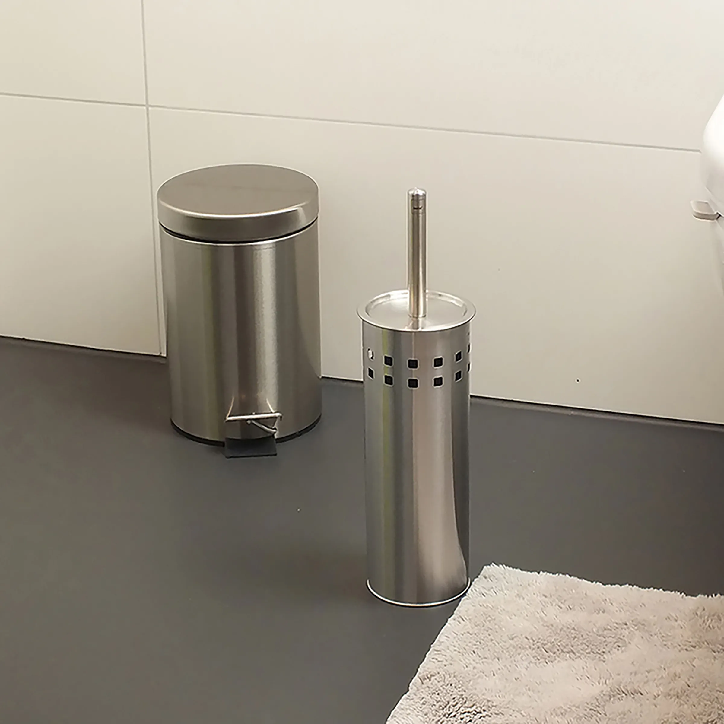 Edelstahl Badezimmer Set - Treteimer & Toilettenbürste Edelstahl-Badezimmer-Set mit Treteimer und Toilettenbürsten-Halter auf dunklem Boden