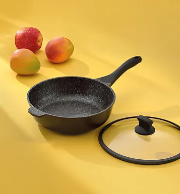 Schwarze Pfanne mit Glassdeckel und schwarzem Griff neben roten Äpfeln auf gelbem Hintergrund