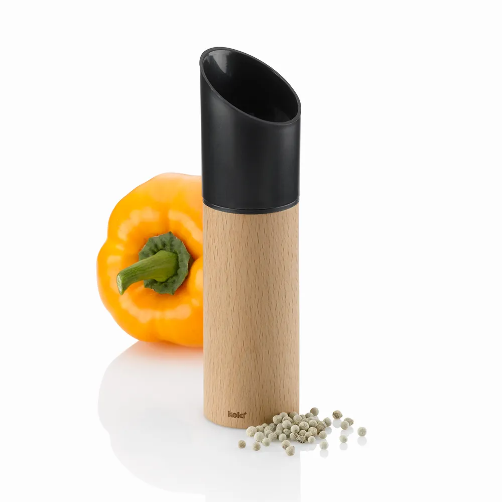 Pfeffermühle Holz mit Keramikmahlwerk - Kela Gewürzmühle für Pfeffer Kela Pfeffermühle aus Holz mit schwarzem Kunststoffkopf, daneben gelbe Paprika und weiße Pfefferkörner