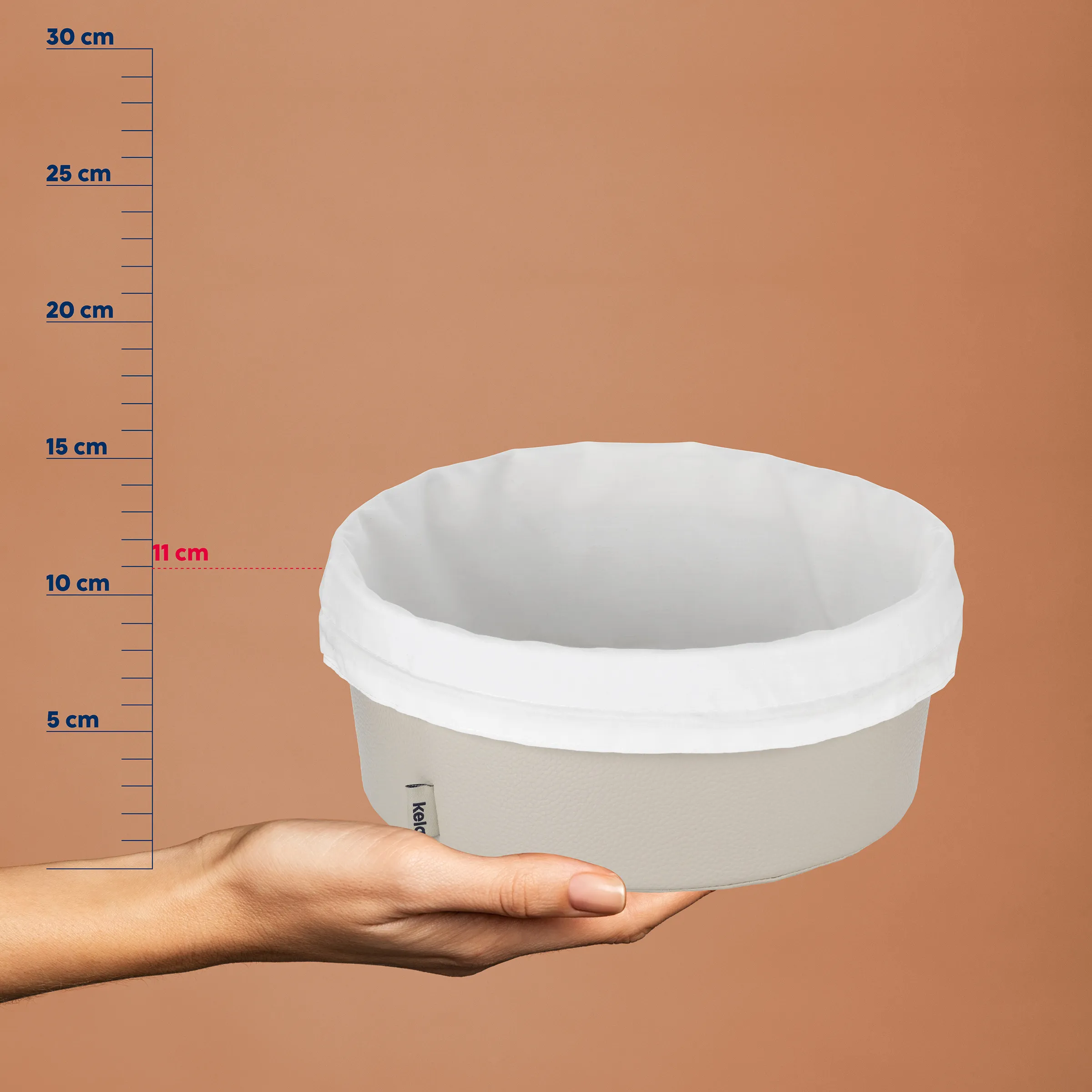 Weiße Keramikschale mit Messstab zeigt Durchmesser von 11 cm, Höhe etwa 10 cm, in Hand gehalten