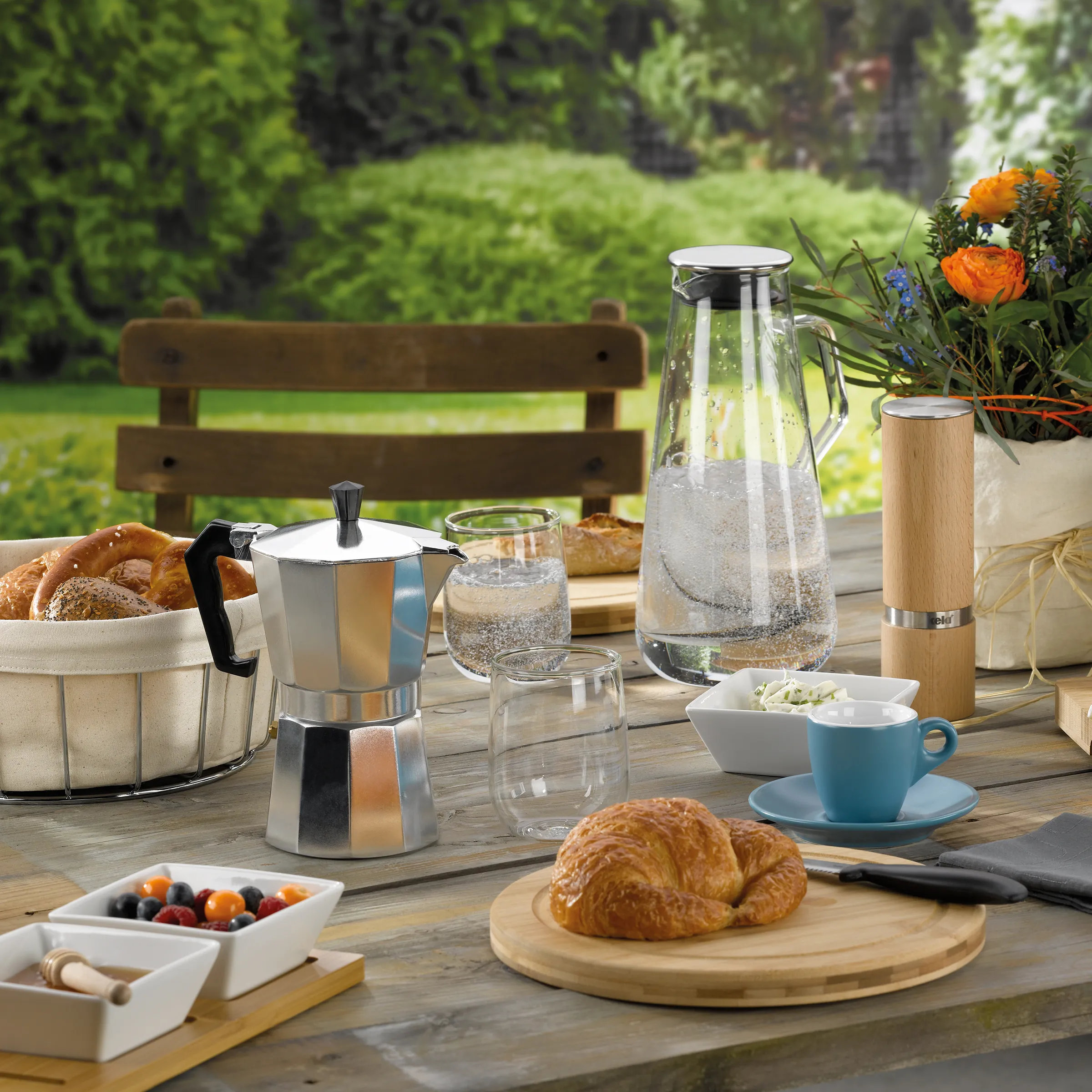 Frühstückstisch Garten - Espressokanne Croissants outdoor Frühstück Gedeckter Frühstückstisch im Garten mit Espressokanne, Croissants, Wasserkaraffe und Blumen