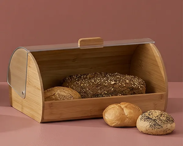 Bambus Brotkasten mit Rolldeckel - Brotaufbewahrung für frisches Brot Bambus Brotkasten mit Rolldeckel gefüllt mit verschiedenen Brotsorten auf rosa Hintergrund