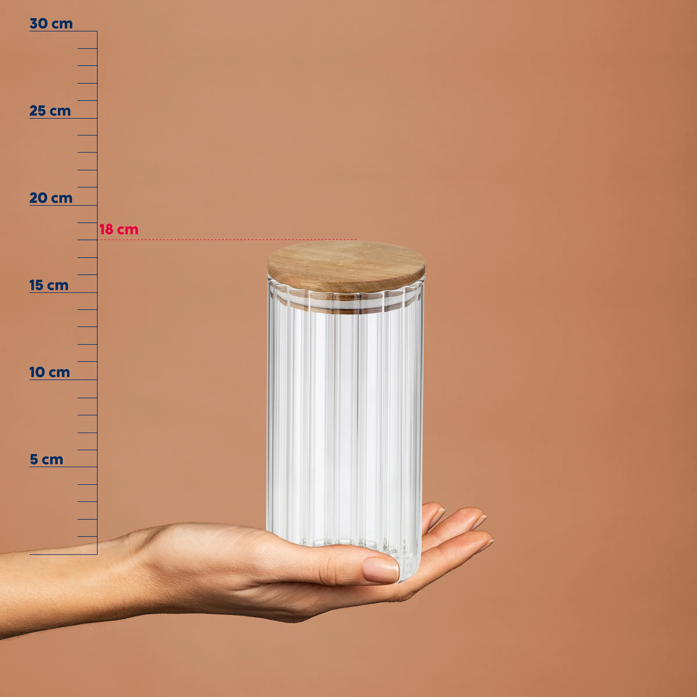 Glaszylinder mit Holzdeckel auf einer Hand vor Größenskala, zeigt 18 cm Höhe